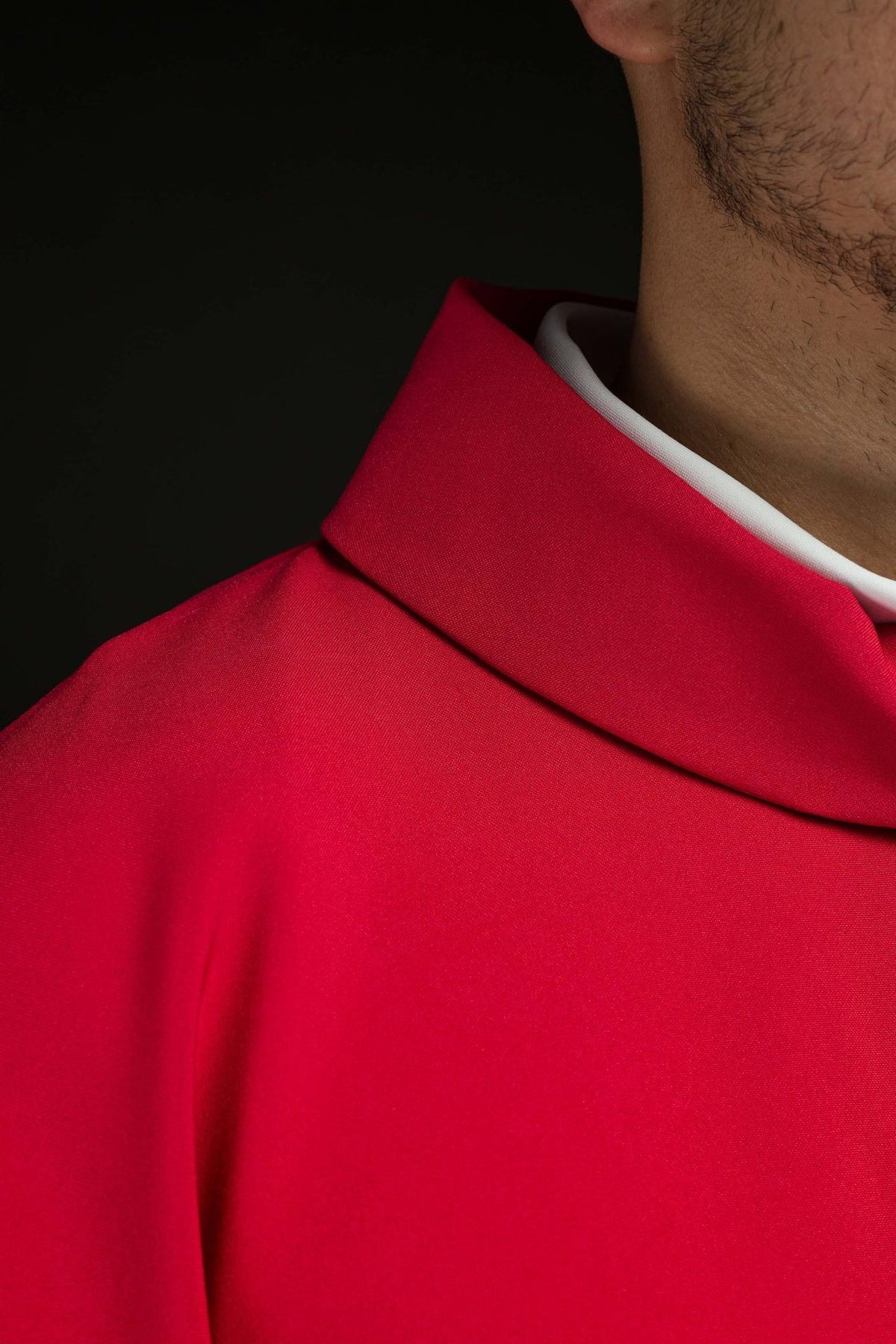 Red chasuble, close-up of sleeve with gold trim and satin fabric