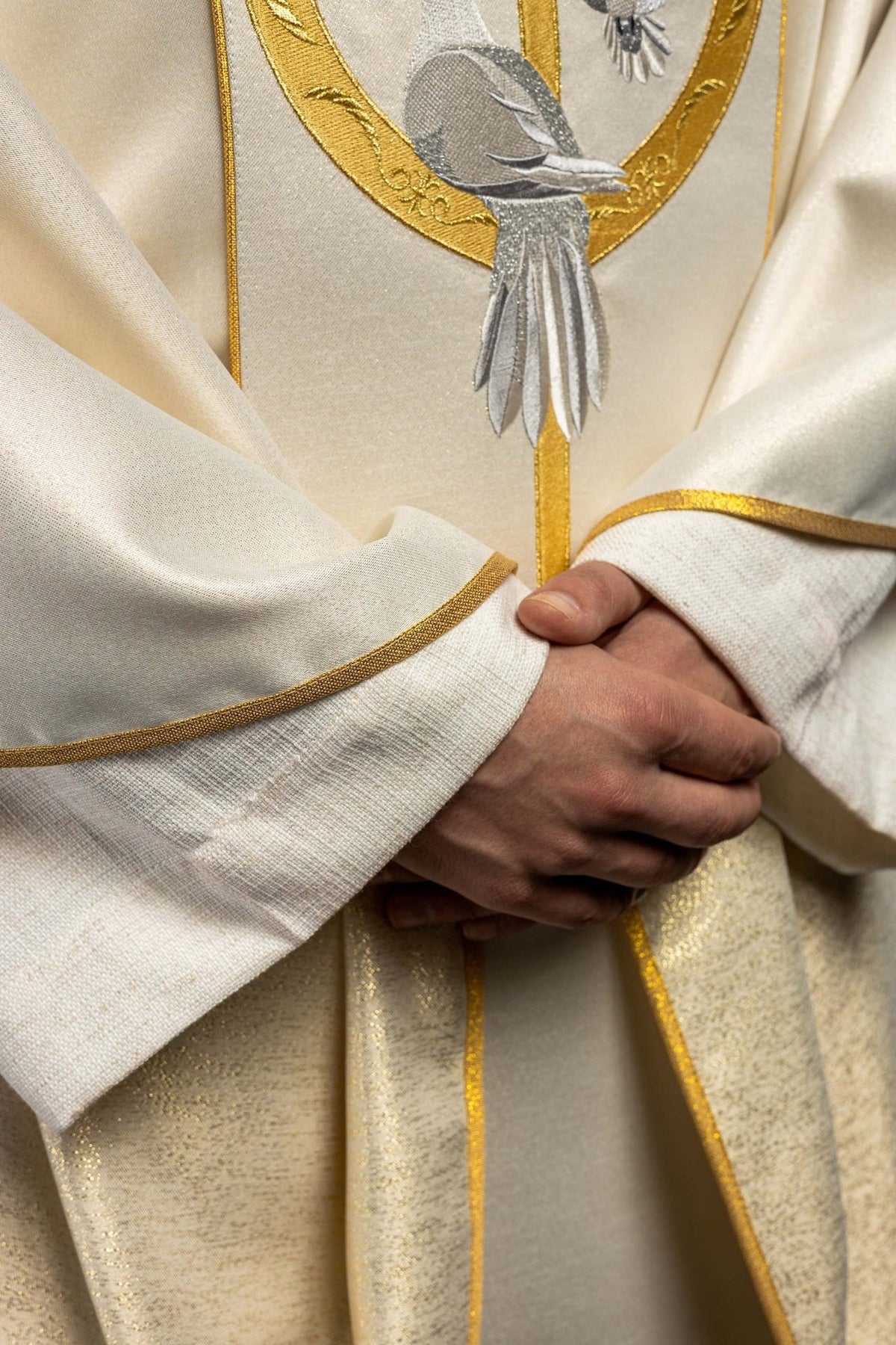 Wedding chasuble detail showing dove embroidery and gold sleeve trim