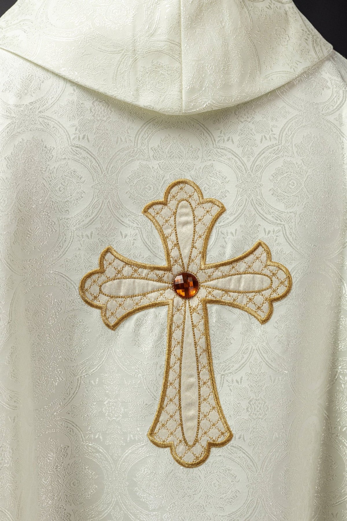 Ecru chasuble close-up of embroidered gold cross with central jewel