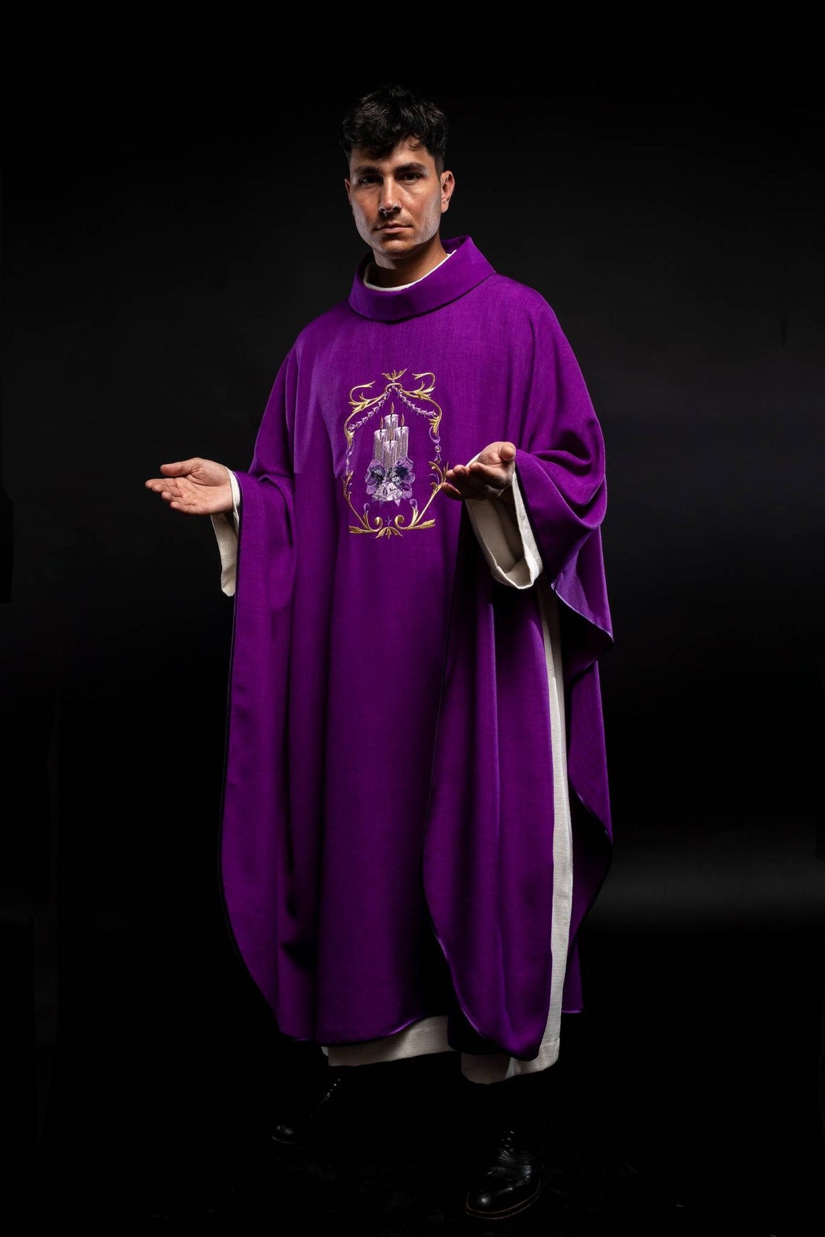 Purple Advent chasuble worn in front view with embroidered candle symbol