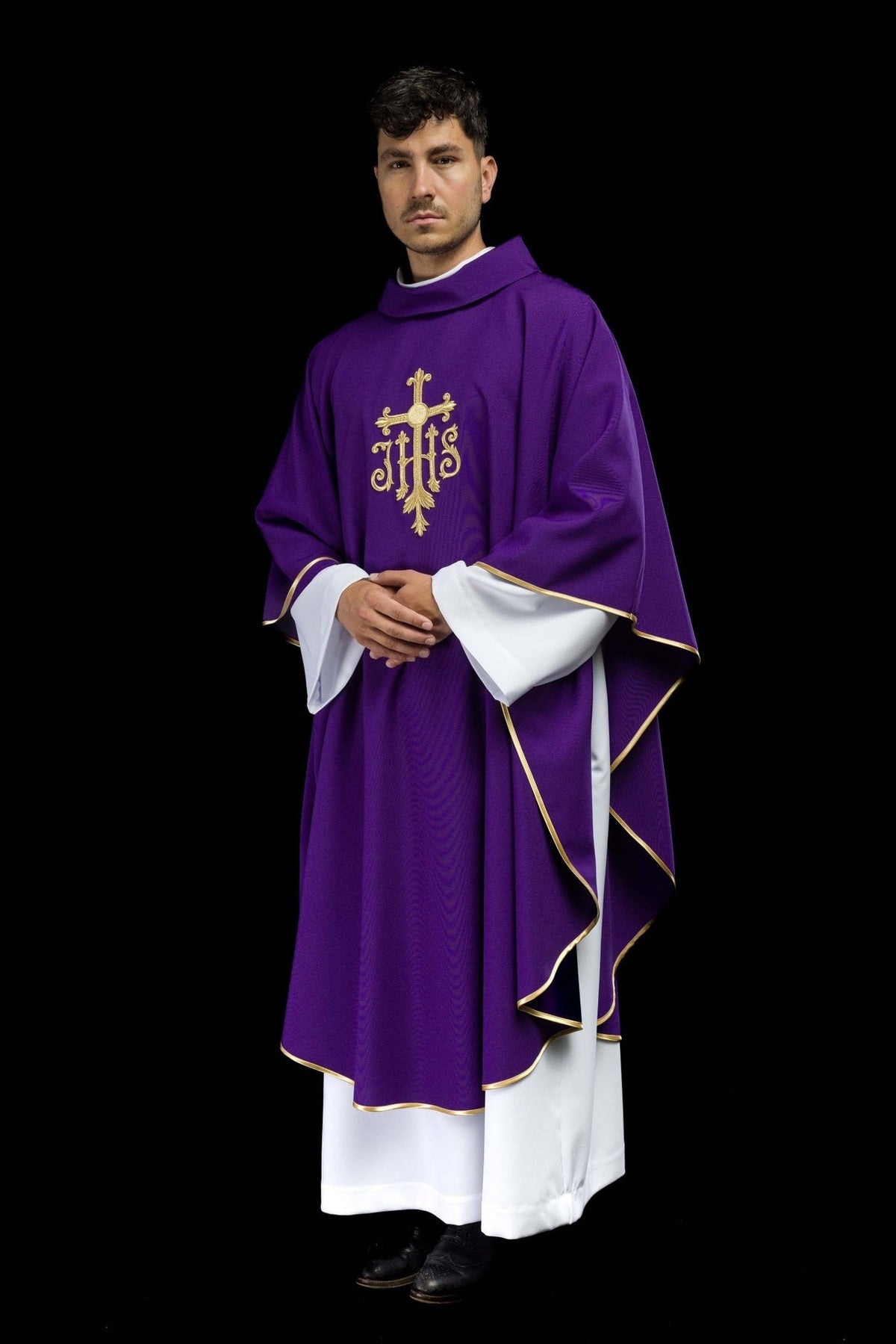 Purple chasuble worn at an angle, showing gold trim and Cross and IHS embroidery
