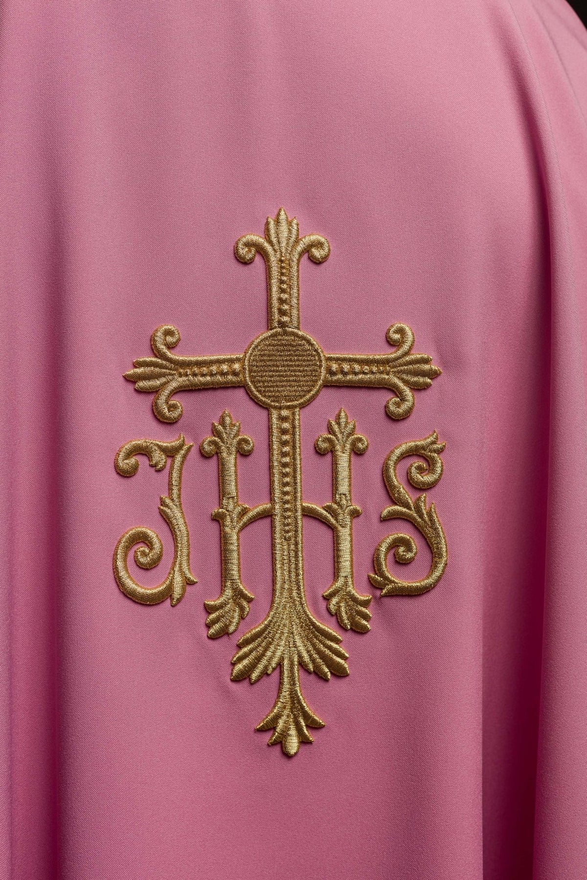Rose chasuble close-up showing raised gold JHS embroidery