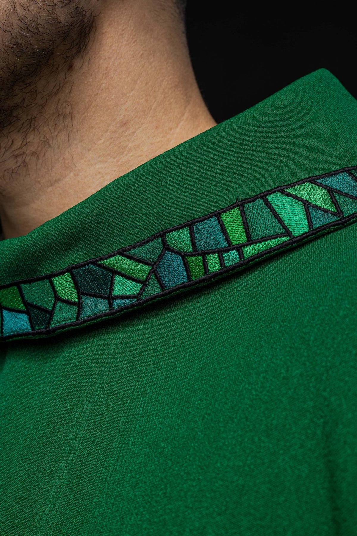 Green chasuble close-up showing mosaic embroidered trim