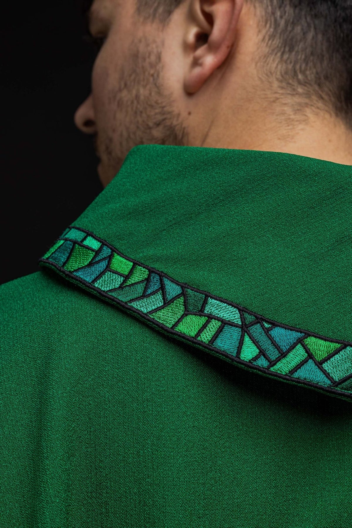 Green chasuble close-up showing lower trim and cross embroidery