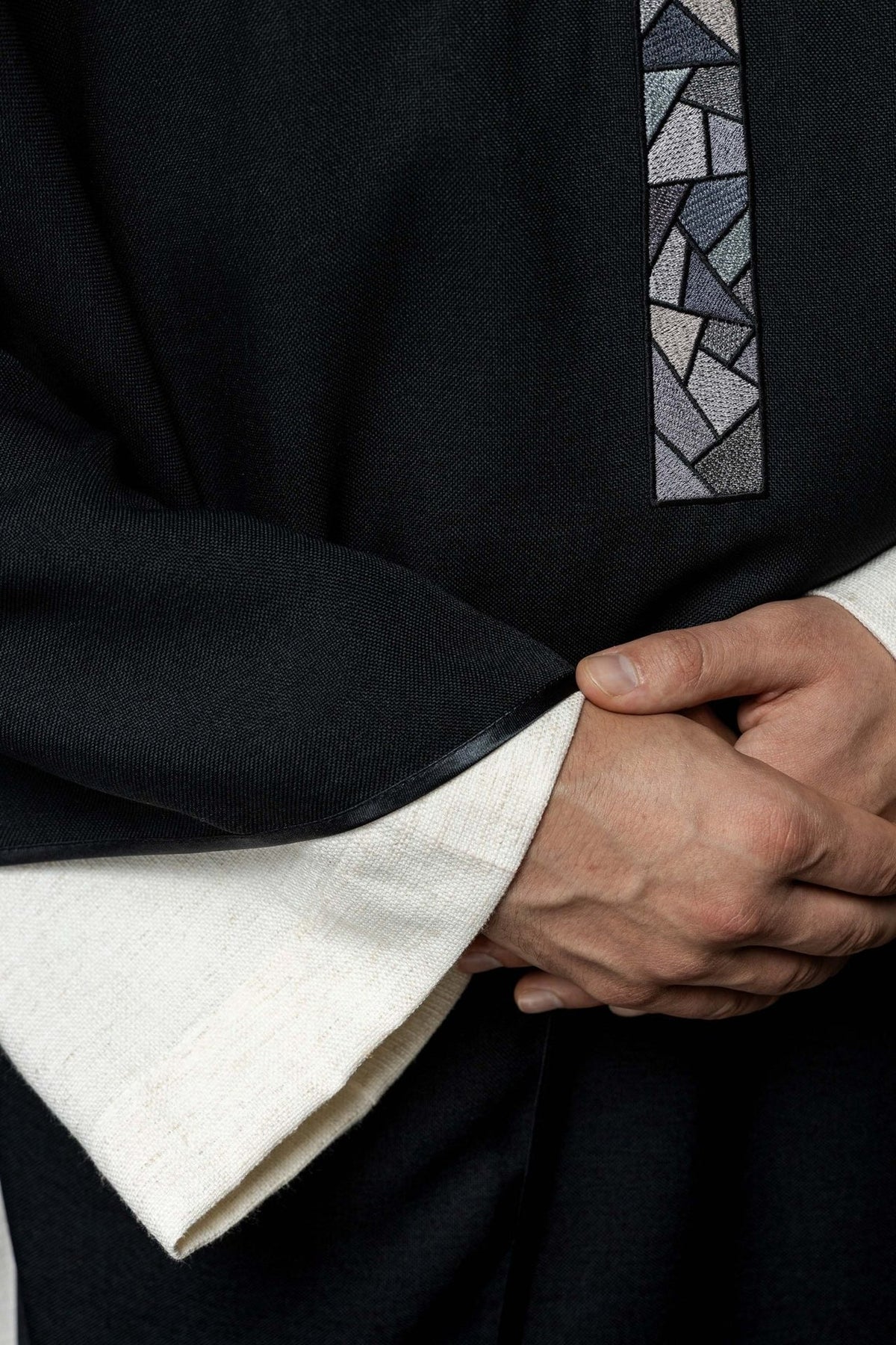 Black chasuble detail showing mosaic cross and black fabric edge