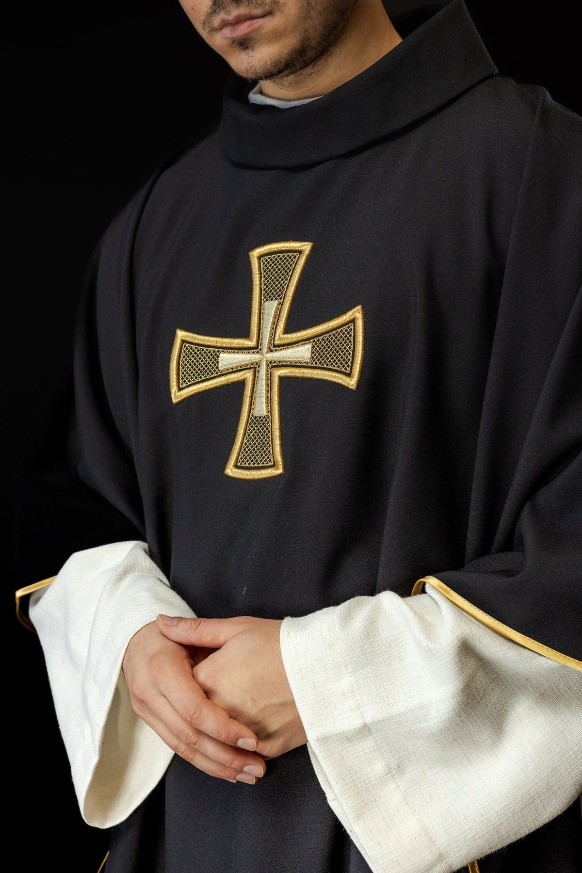 Black chasuble close-up showing gold cross embroidery and stand-up collar