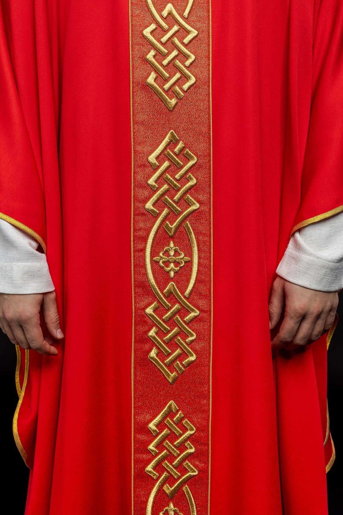 Red chasuble close-up showing lower central gold embroidery and trim