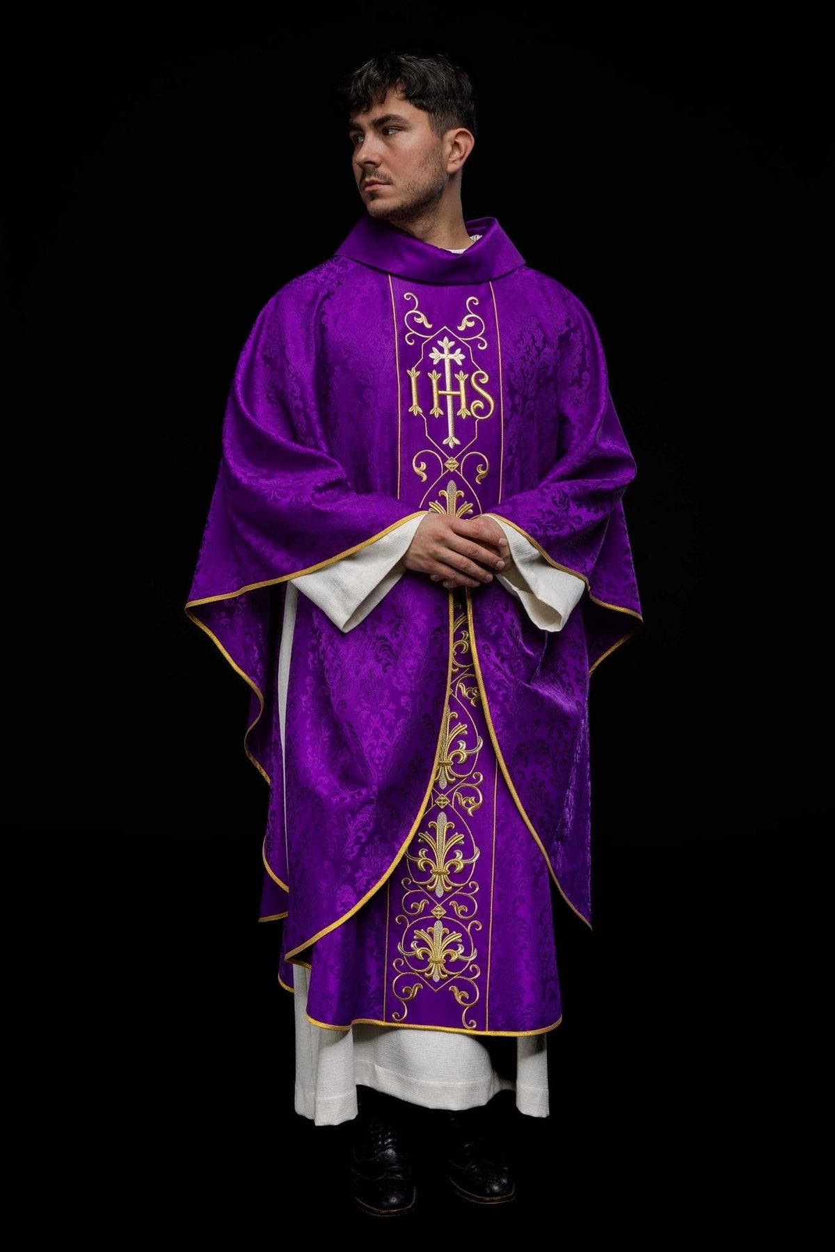 Purple chasuble front view showing embroidered IHS panel, floral motifs and gold trim