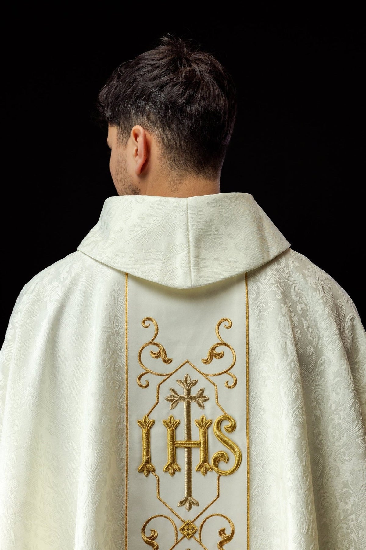 Ecru chasuble side view showing damask fabric, gold trim and embroidered front panel