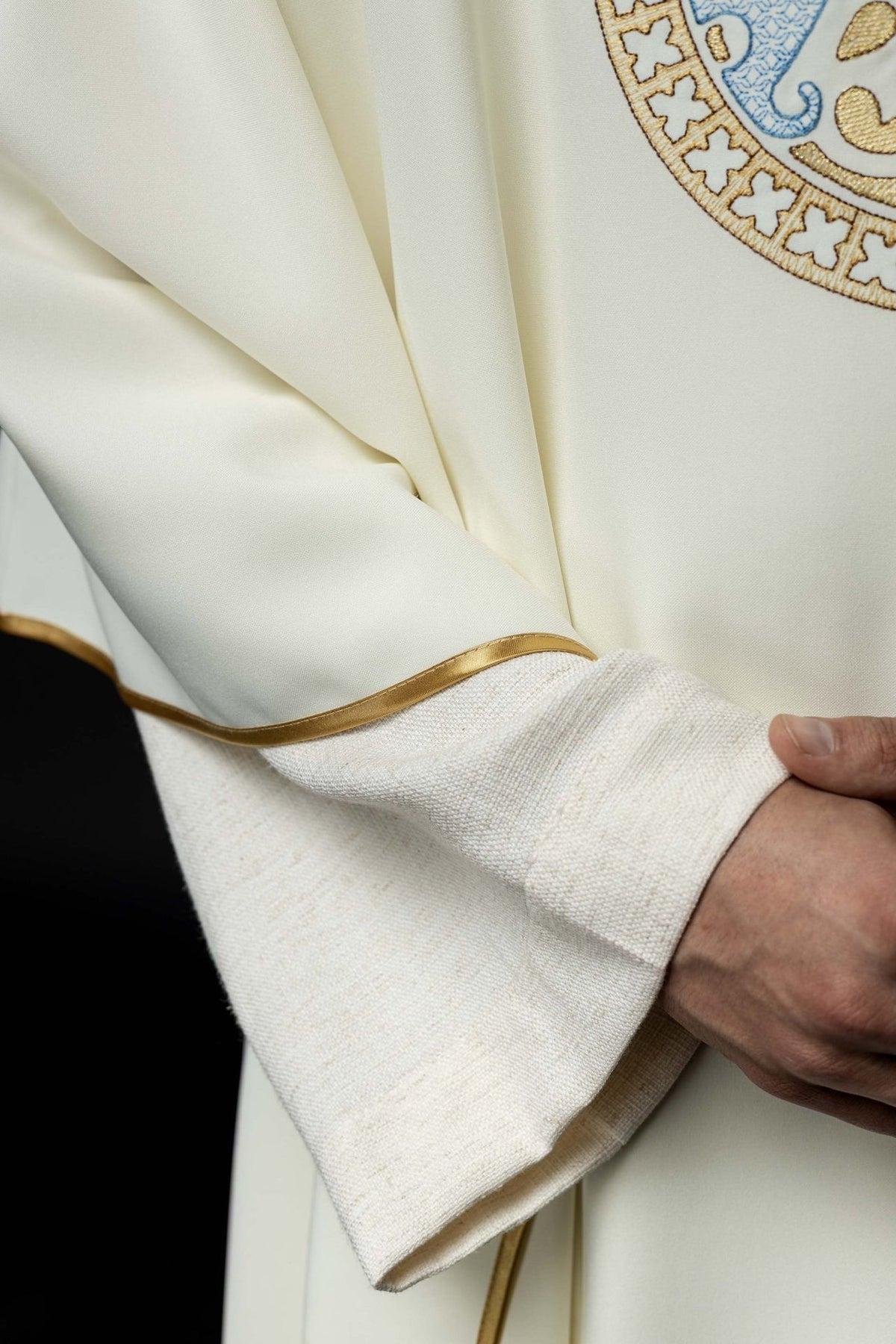 Marian chasuble sleeve close-up showing ecru fabric and gold trim