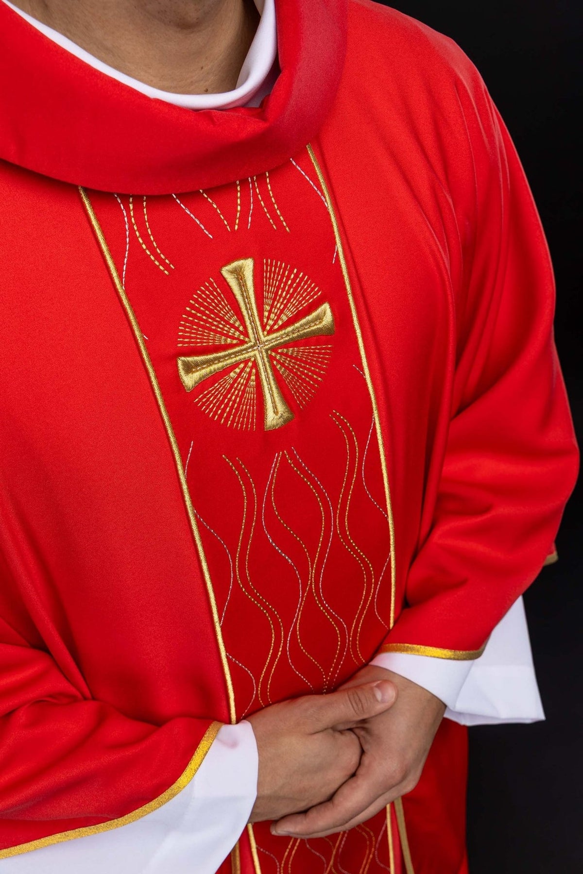 Red chasuble close-up showing gold cross embroidery and wavy orphrey embroidery