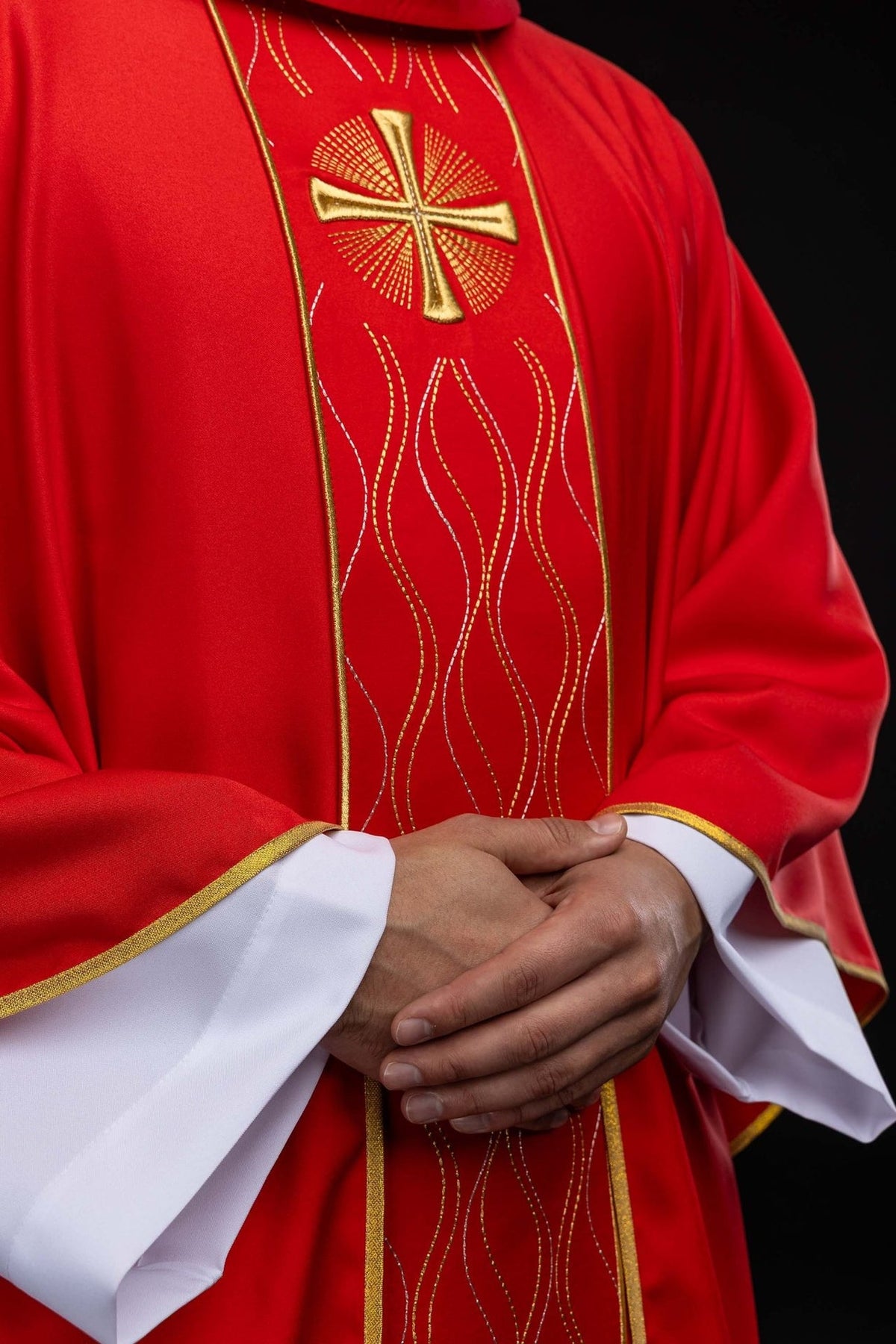 Red chasuble close-up showing gold and silver wavy embroidery on the orphrey
