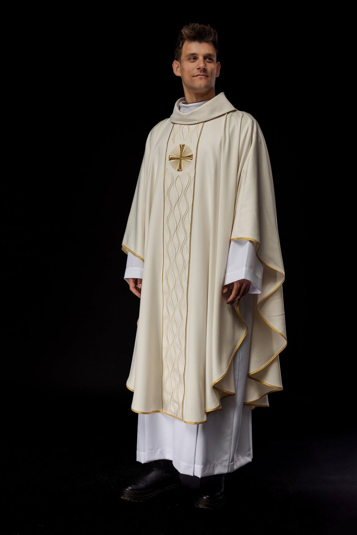 Ecru chasuble worn three-quarter view with gold cross embroidery and flowing gold trim