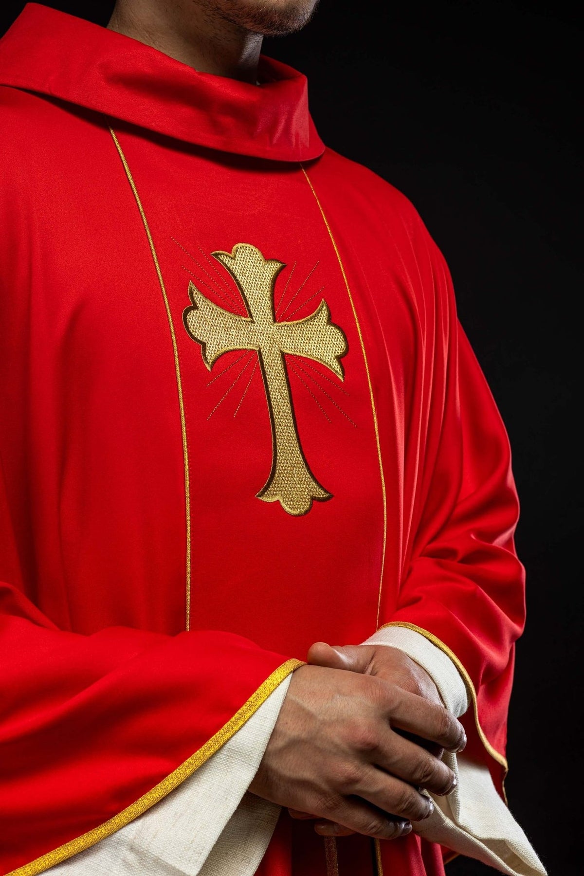 Red chasuble close-up with embroidered gold cross and stand-up collar