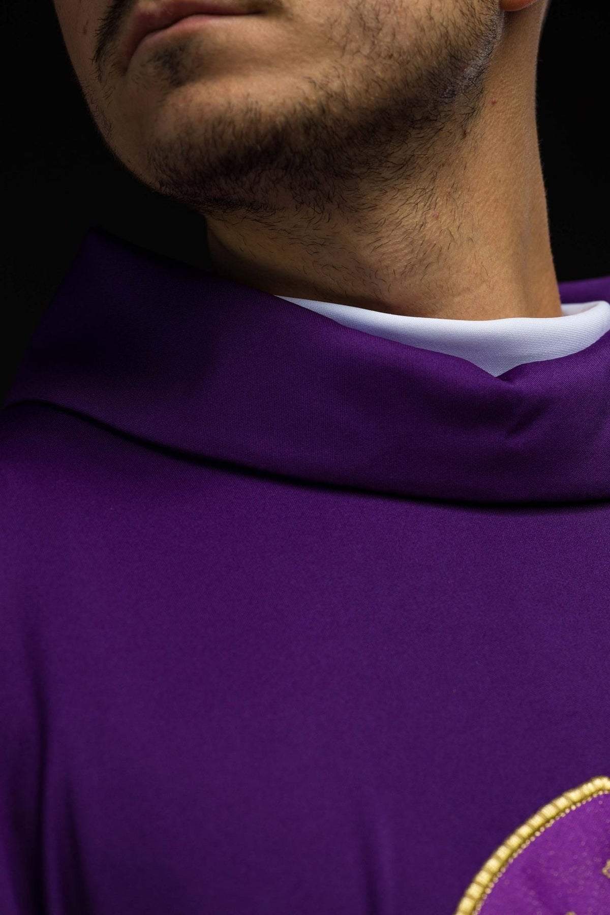 Purple chasuble close-up showing stand-up collar and knit fabric