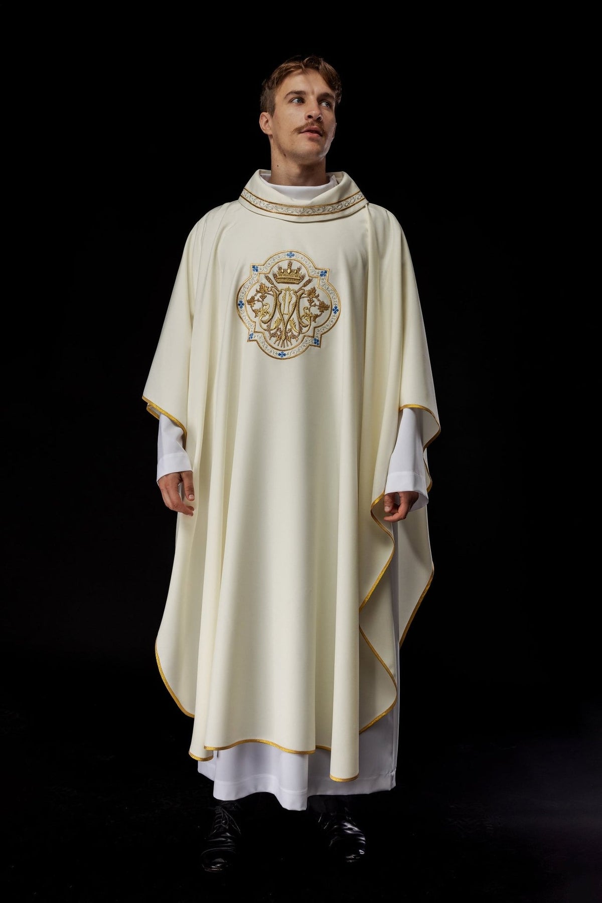 Ecru chasuble worn from the front, showing flowing shape and gold trim