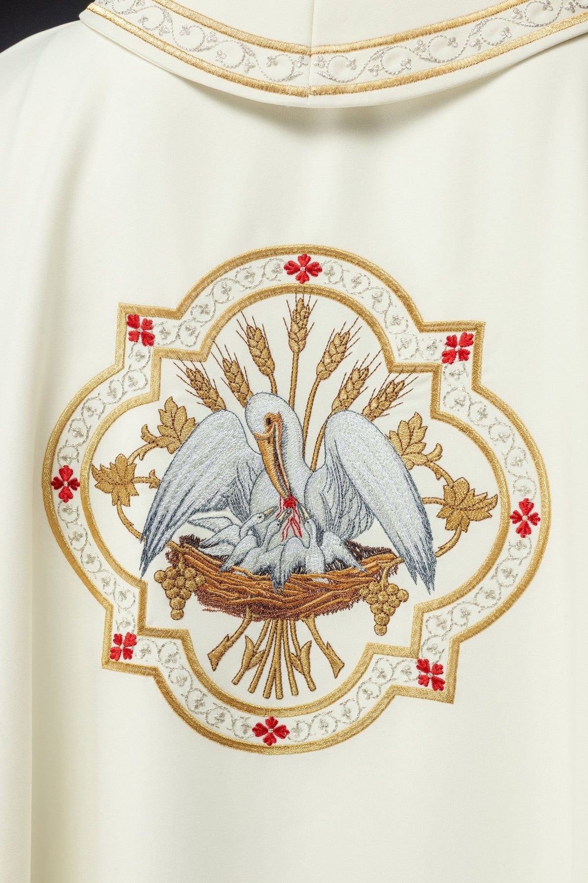 Ecru chasuble back close-up with embroidered pelican motif and gold trim