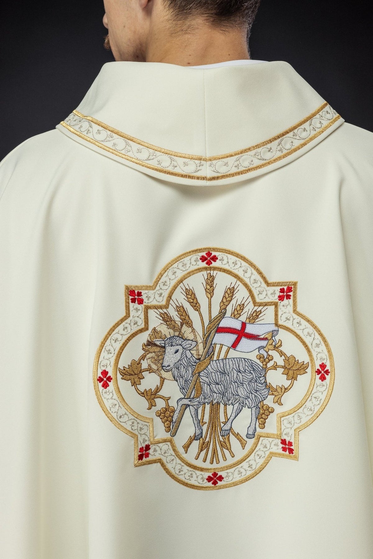 Ecru chasuble side detail showing flowing fabric and gold-trimmed edge
