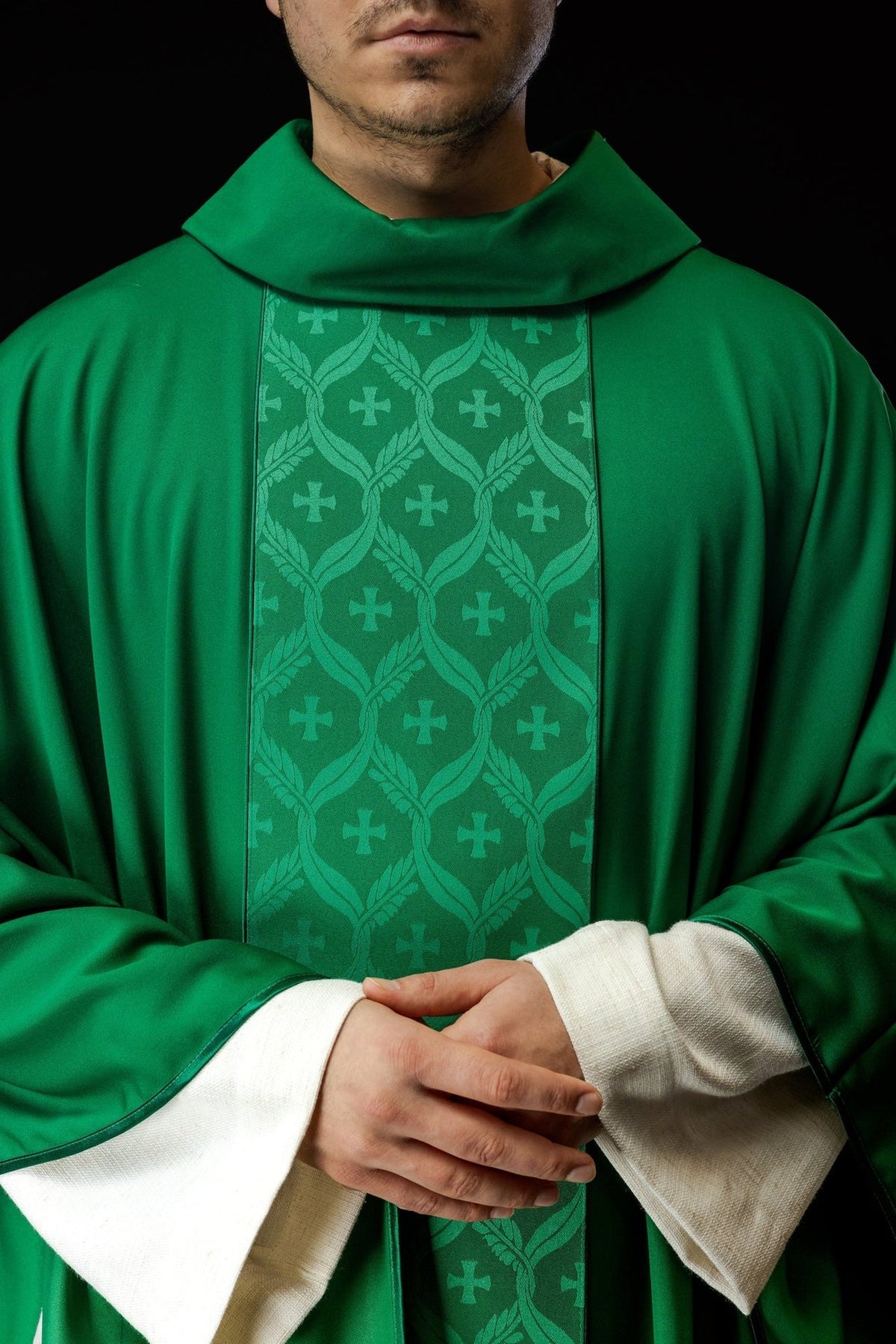 Green chasuble front detail showing jacquard orphrey with leafy motifs and crosses
