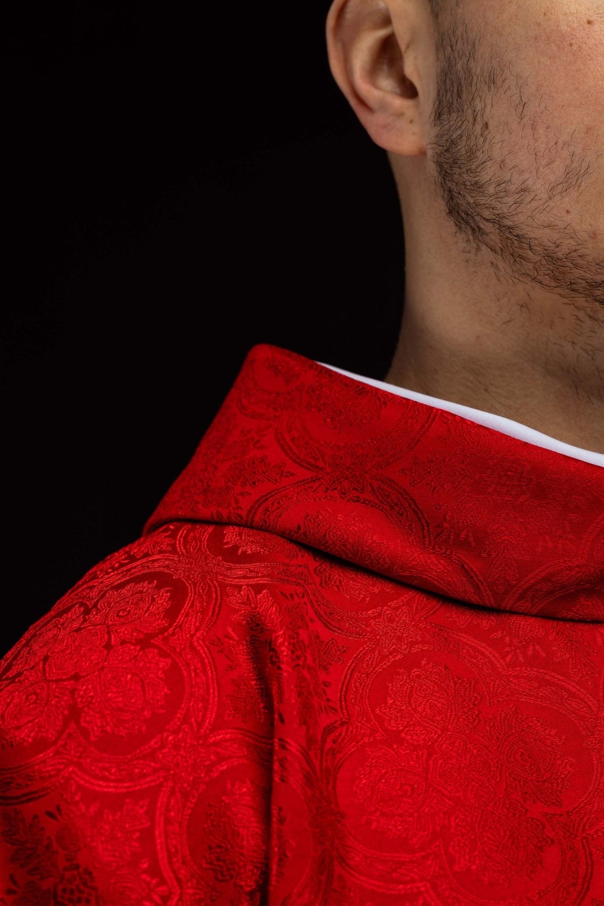 Red chasuble sleeve detail with white cuff and gold trim