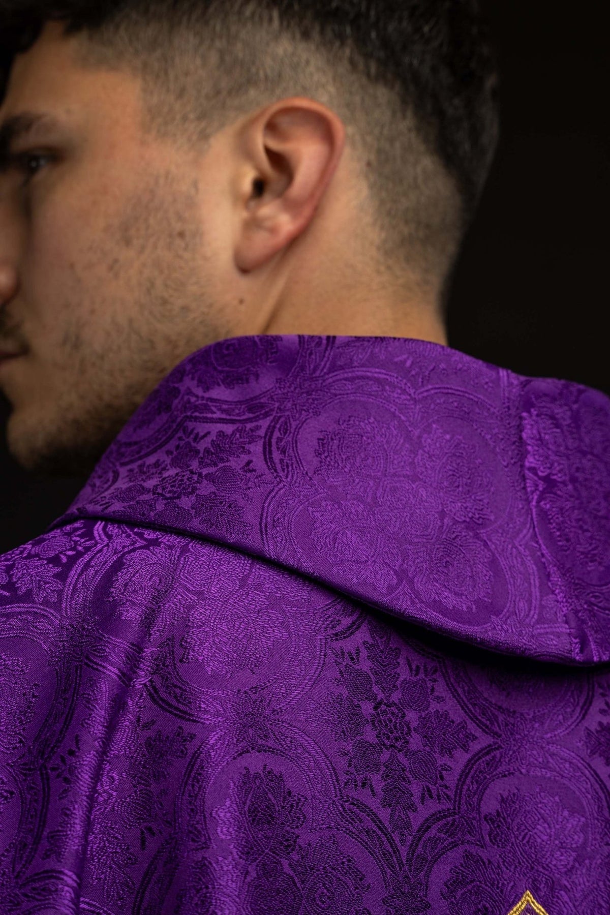 Purple chasuble close-up showing patterned shoulder and stand-up collar