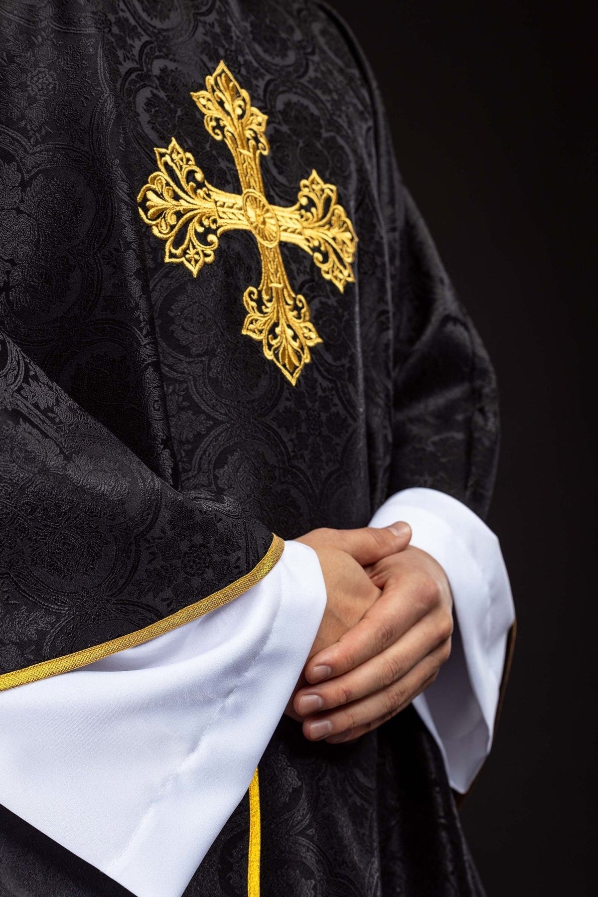 Black chasuble front detail showing gold embroidery and satin trim
