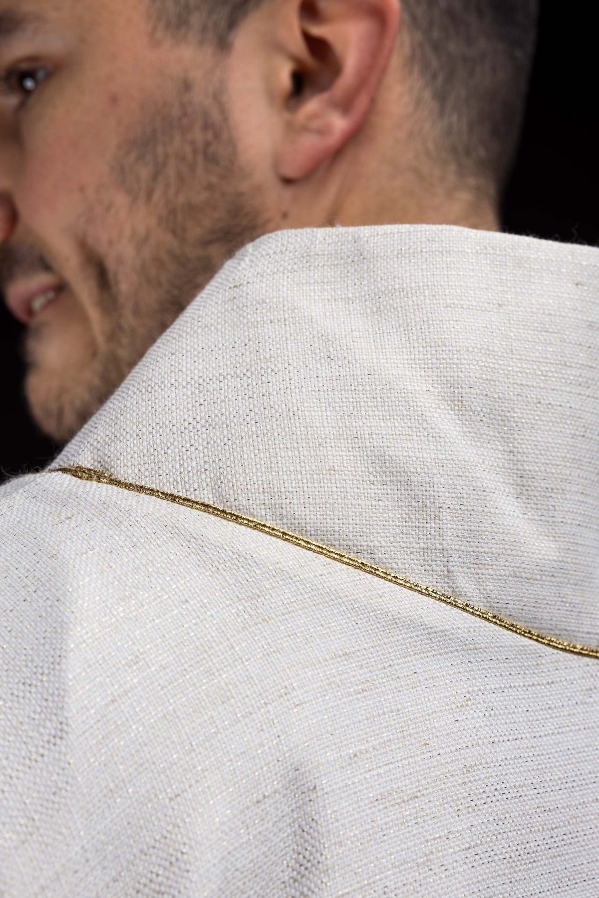 Chasuble back detail with gold trim around the collar