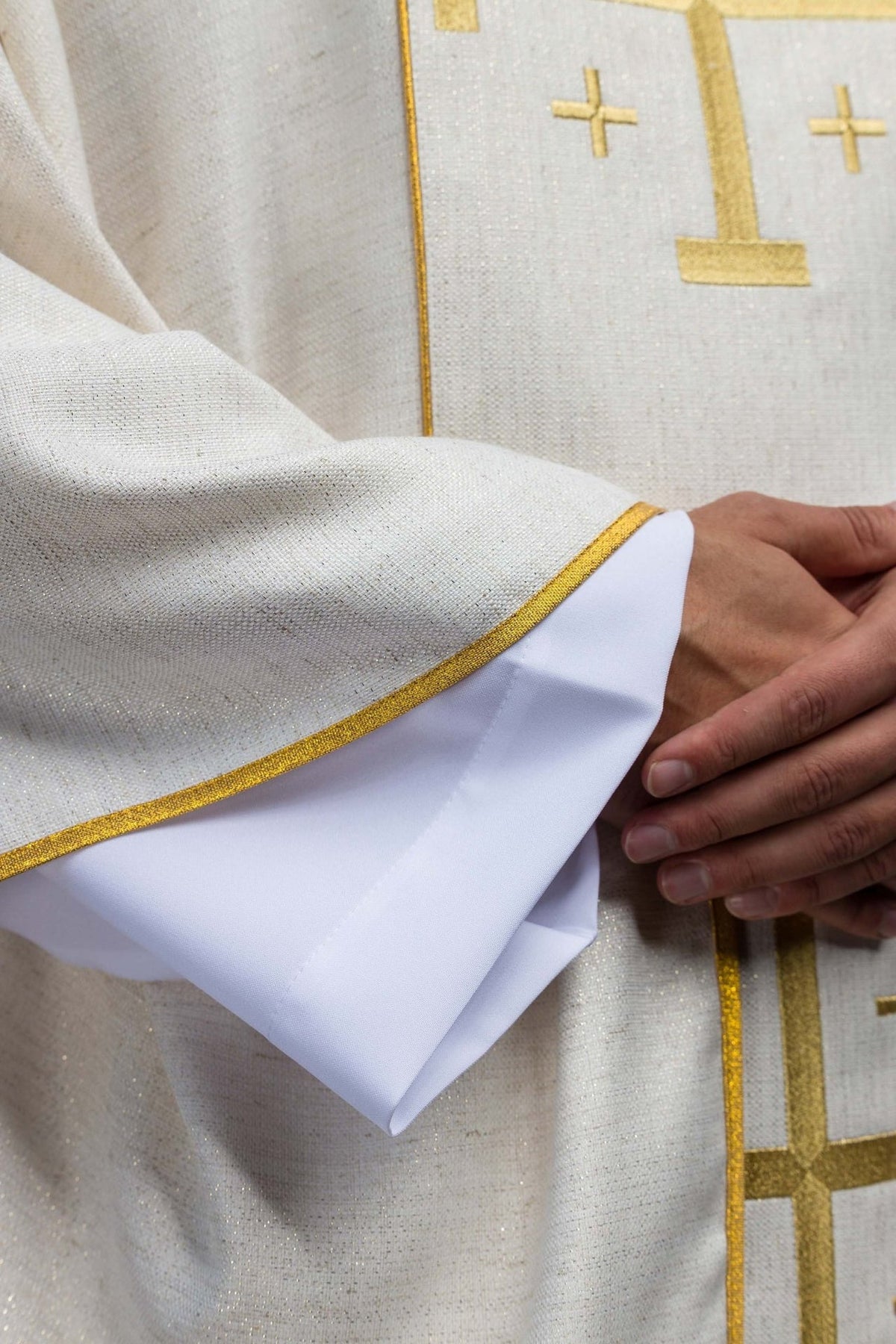 Ecru chasuble sleeve close-up with gold trim and white cuff