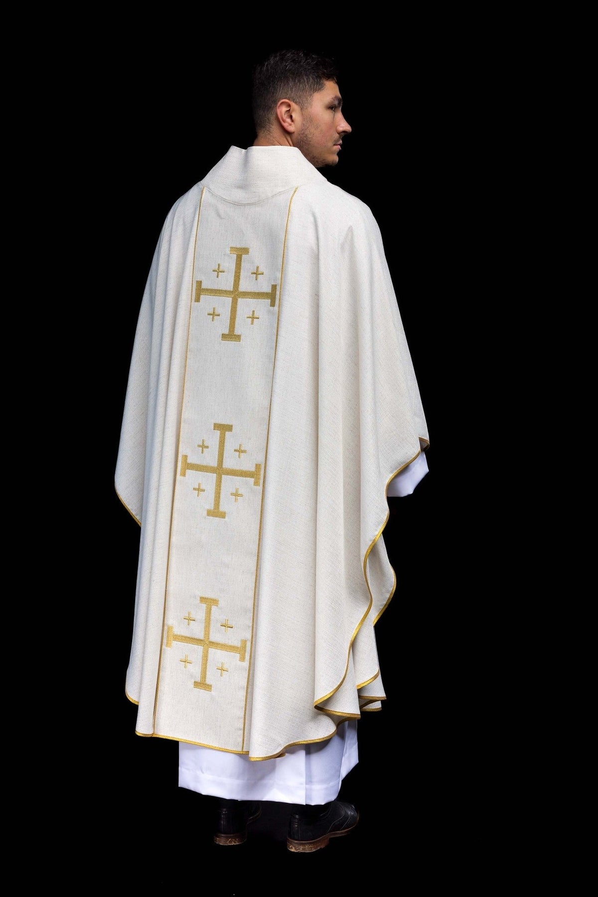 Rear three-quarter view of embroidered ecru chasuble with gold trim