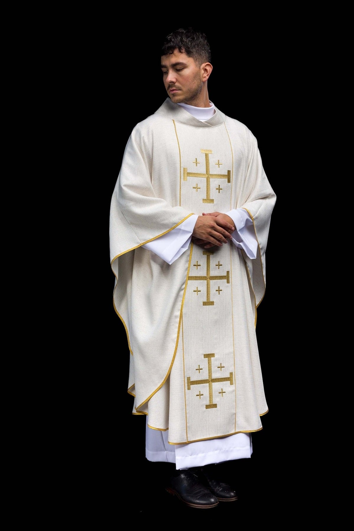 Three-quarter front view of ecru chasuble with gold Jerusalem cross embroidery