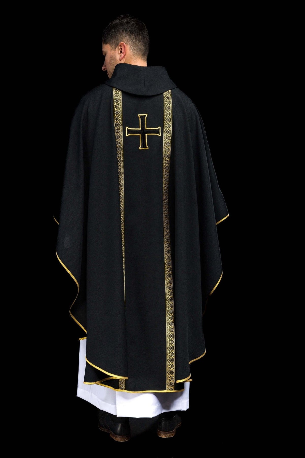 Black chasuble back view with central gold orphrey and embroidered cross