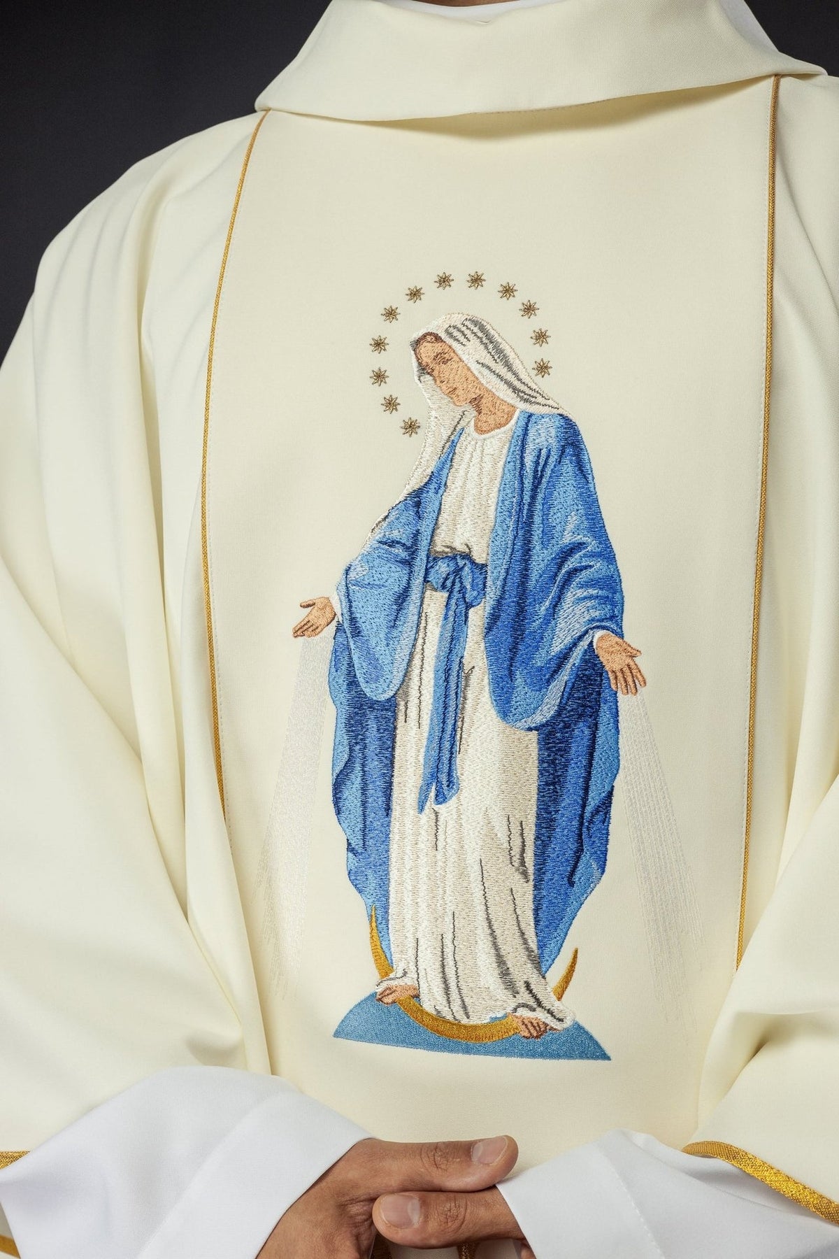 Catholic chasuble close-up showing embroidered Our Lady in blue and ivory with gold trim