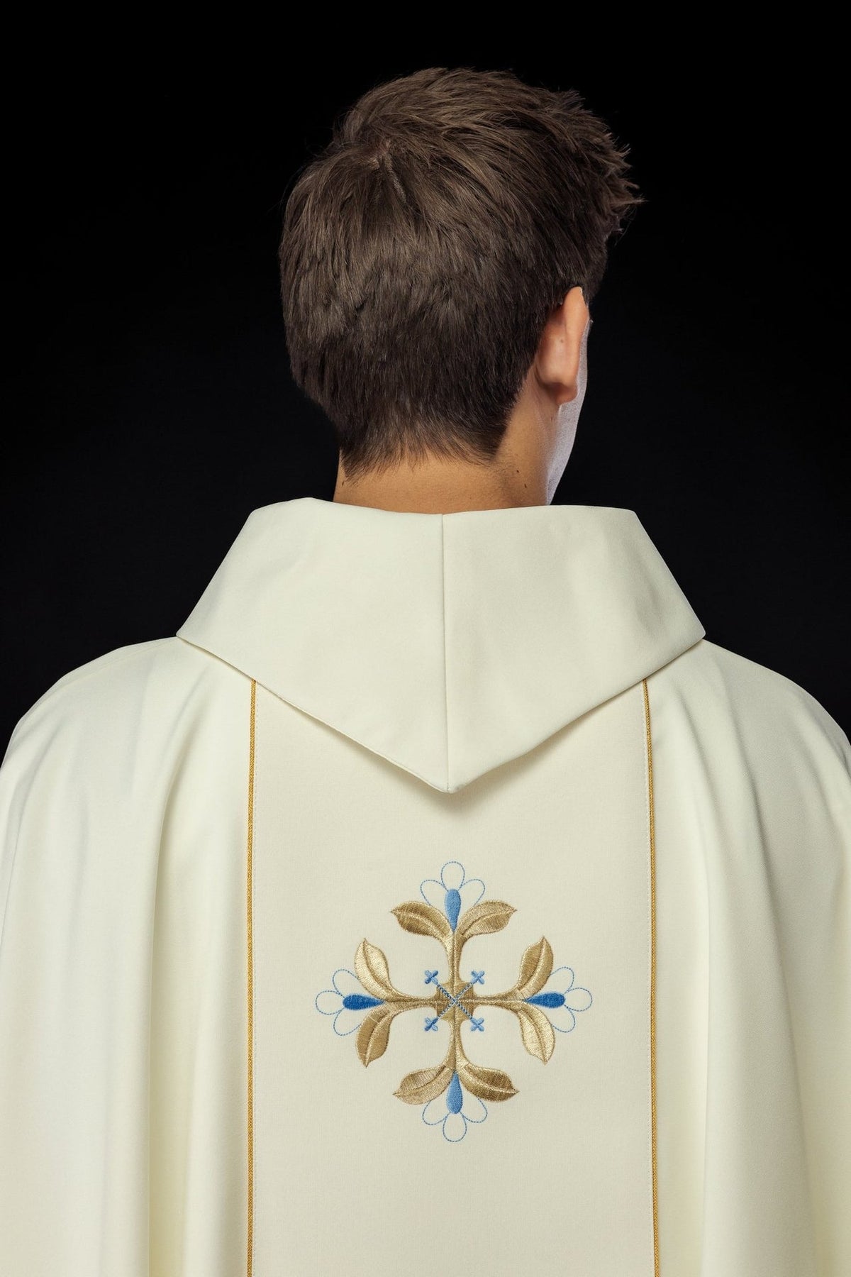 Ivory chasuble back view with gold trim and embroidered blue and gold floral motifs