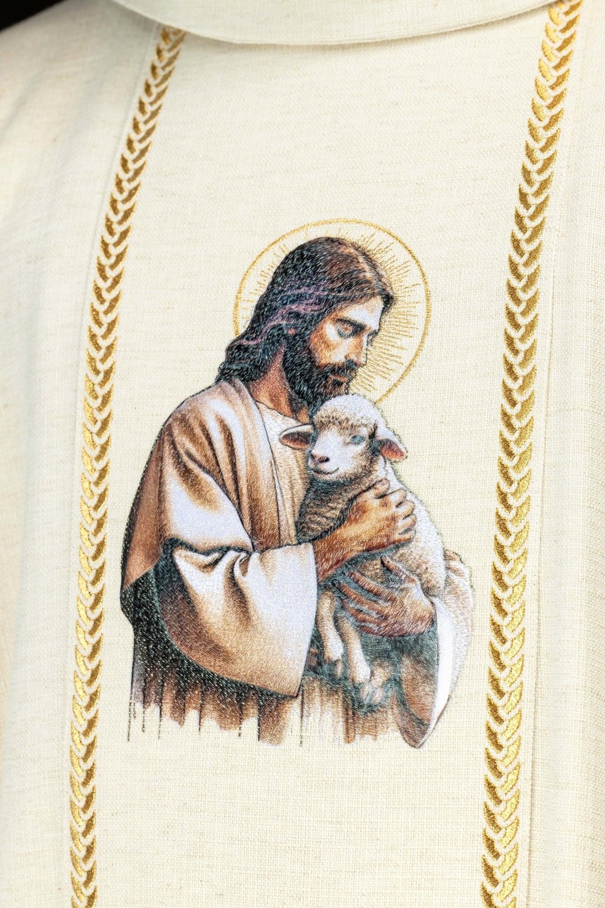 Ecru chasuble close-up showing embroidered Good Shepherd image and gold trim