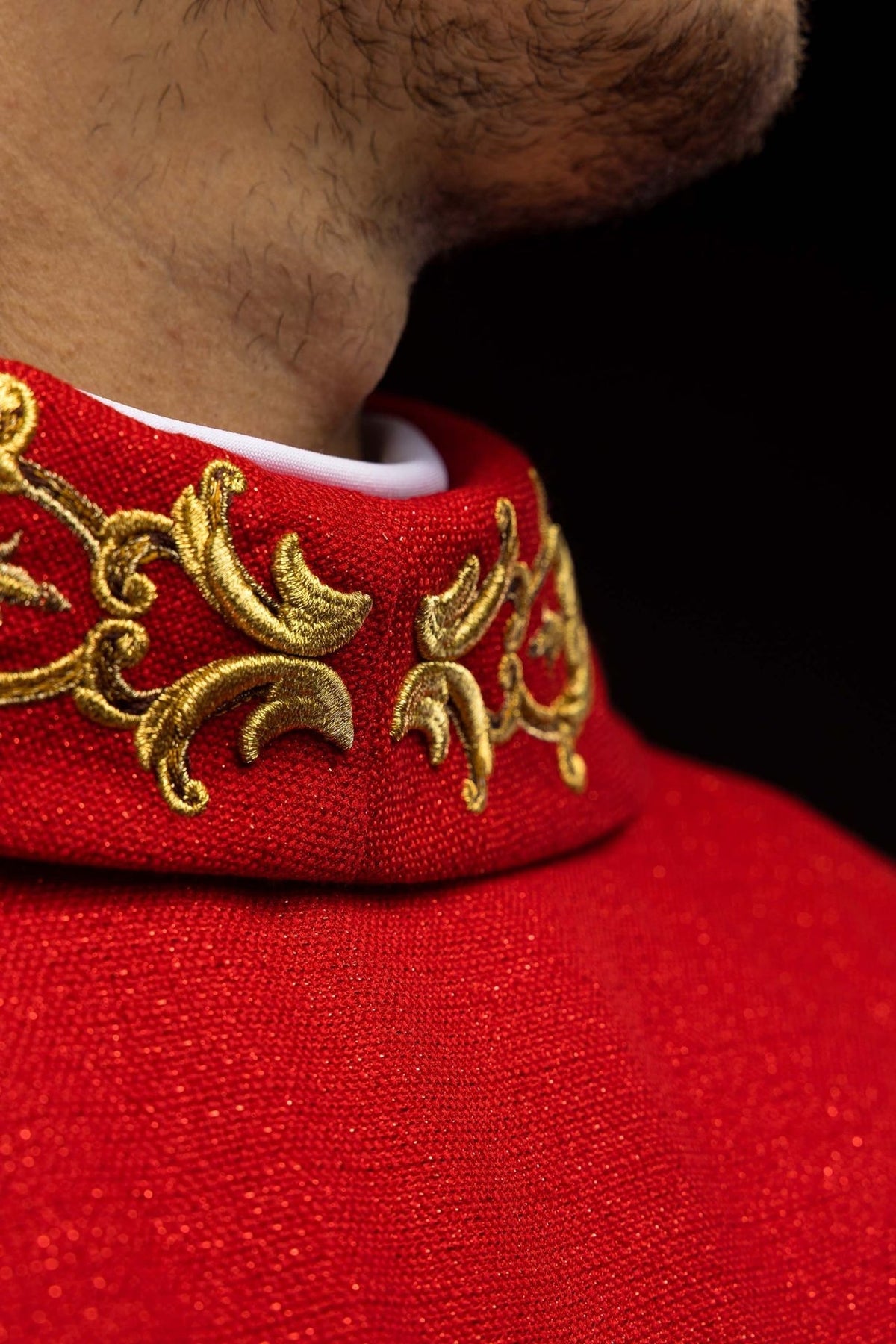 Red chasuble detail showing the red fabric and sleeve edge