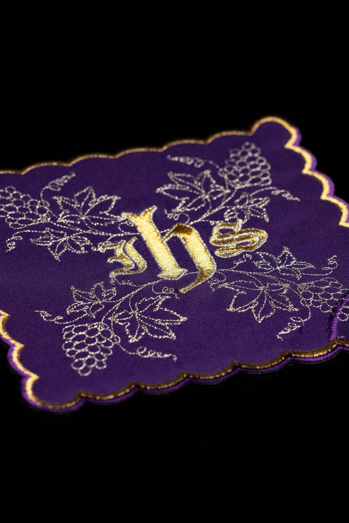 Purple chalice pall close-up with gold IHS and embroidered grapes and vine