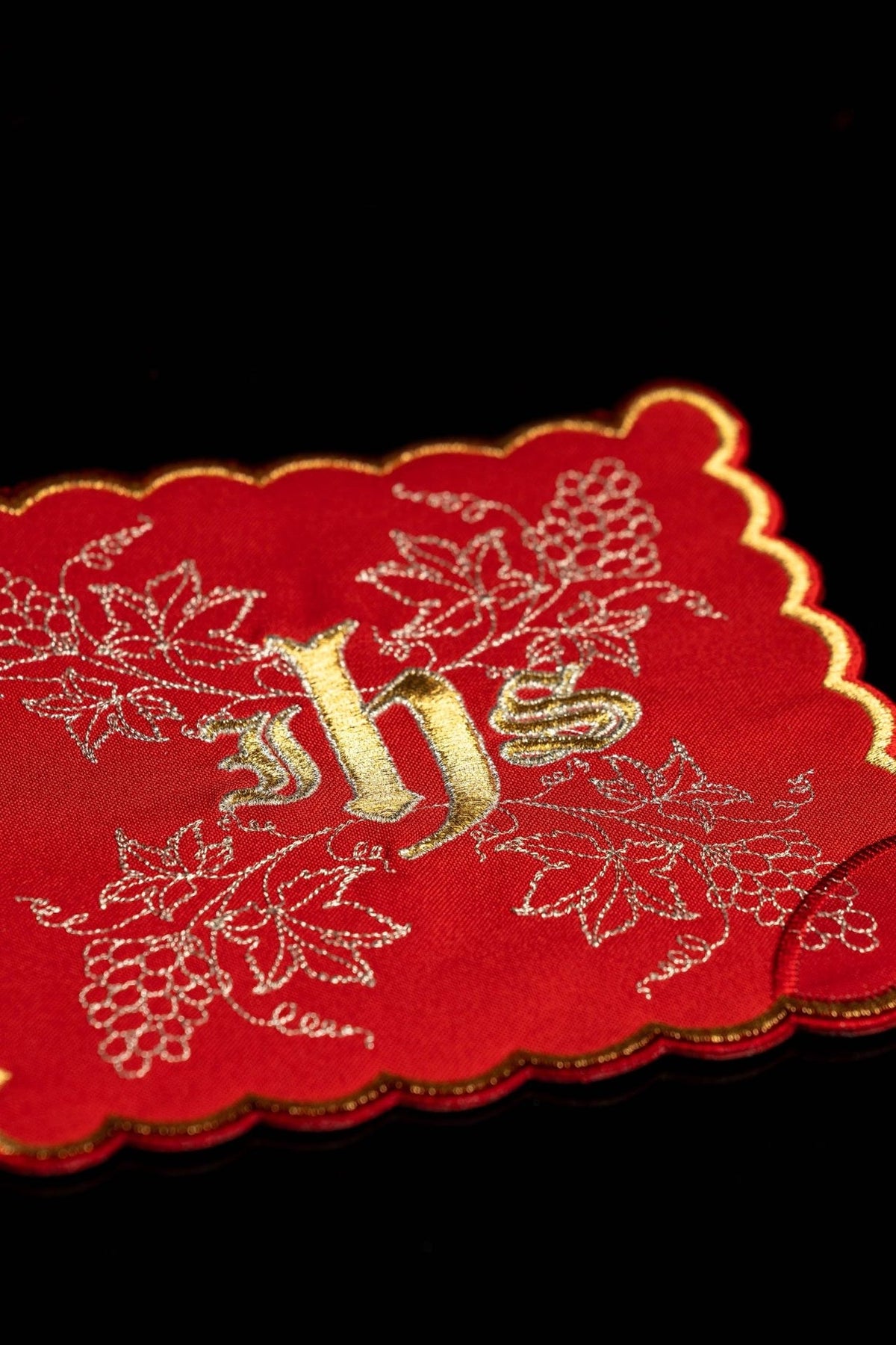 Red chalice pall close-up with gold IHS and embroidered grapes and vine