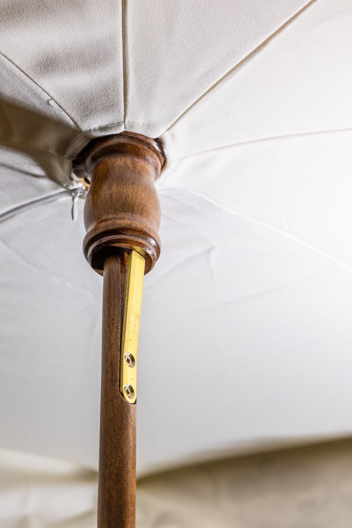 Ecru processional umbrella underside detail with wooden pole and metal support
