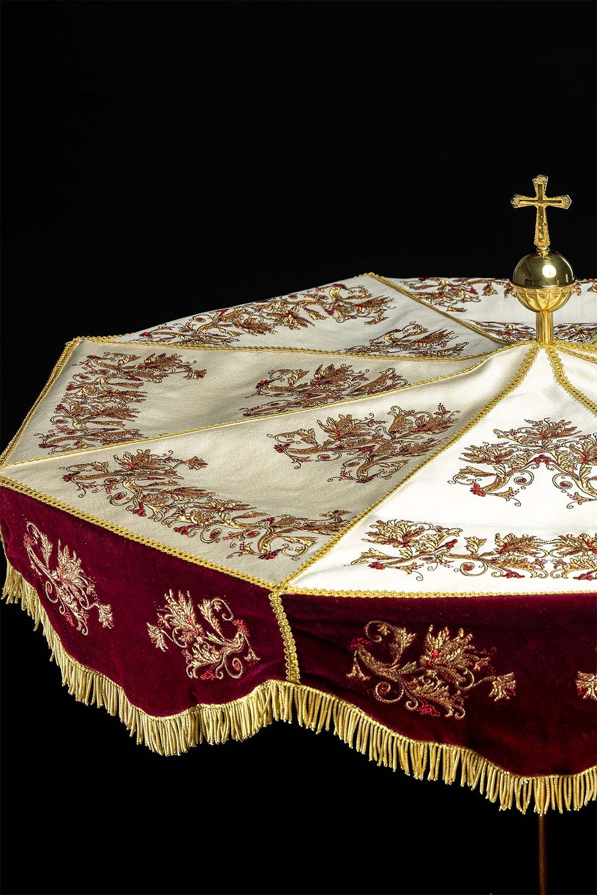 Processional umbrella close-up showing ecru canopy, burgundy valance and gold fringe