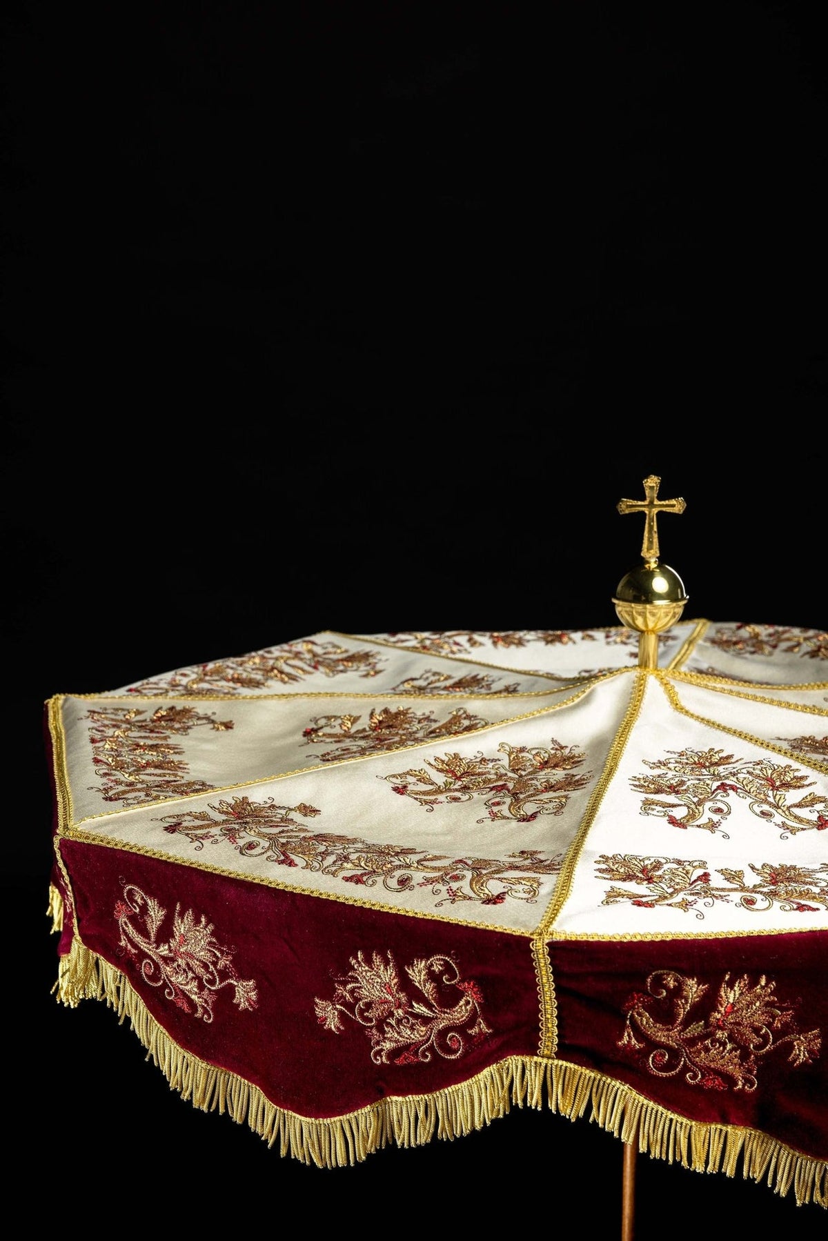 Processional umbrella angled view with embroidered ecru panels and burgundy velvet valance