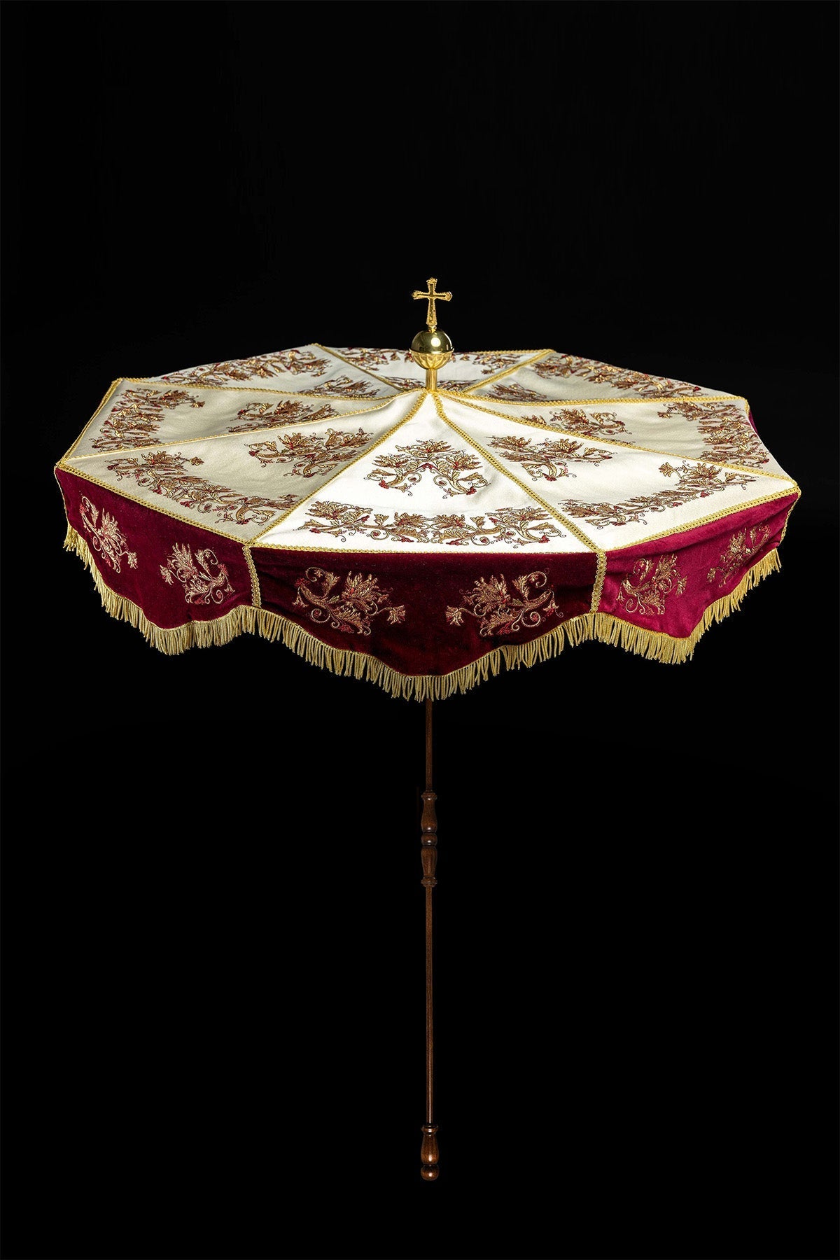 Processional umbrella full view with burgundy and ecru canopy, cross finial and wooden pole