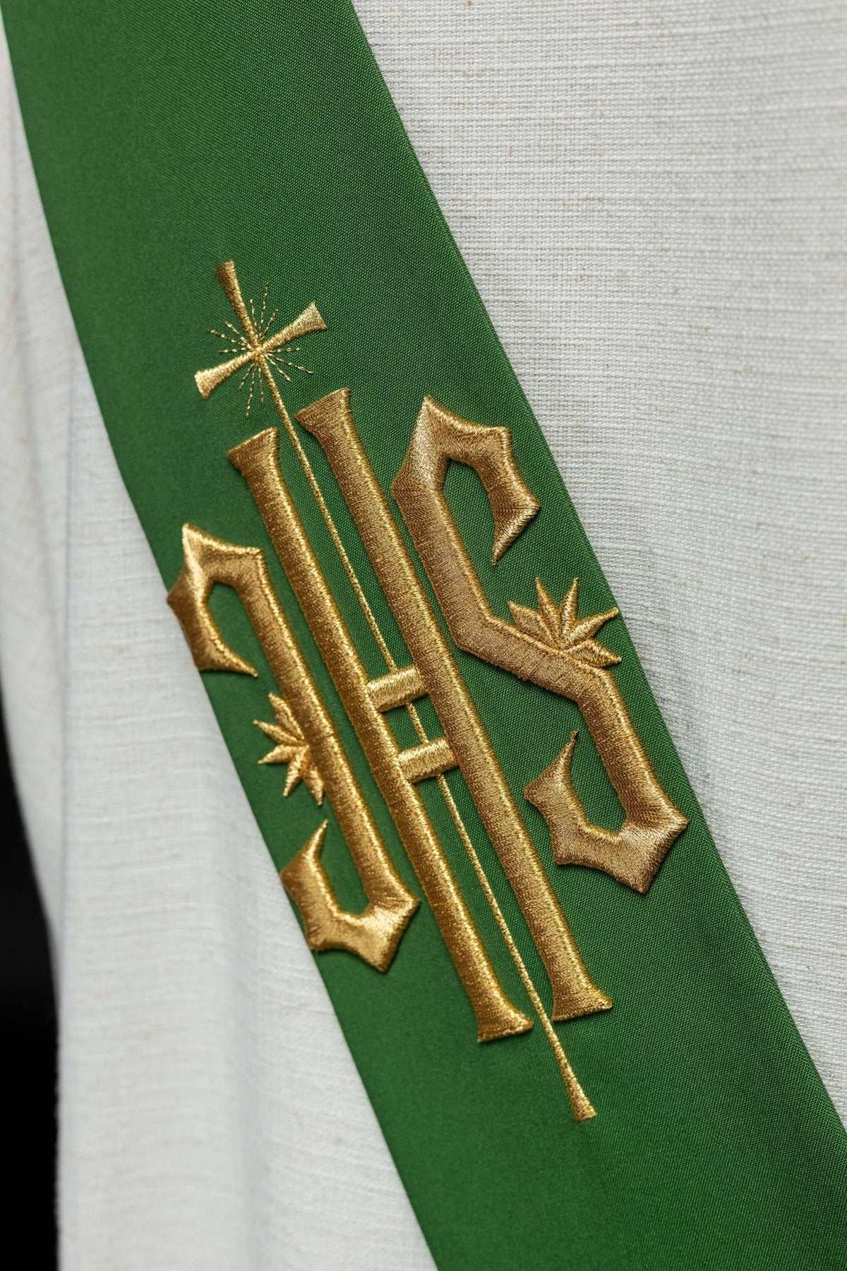 Green stole close-up showing detailed gold IHS and cross embroidery