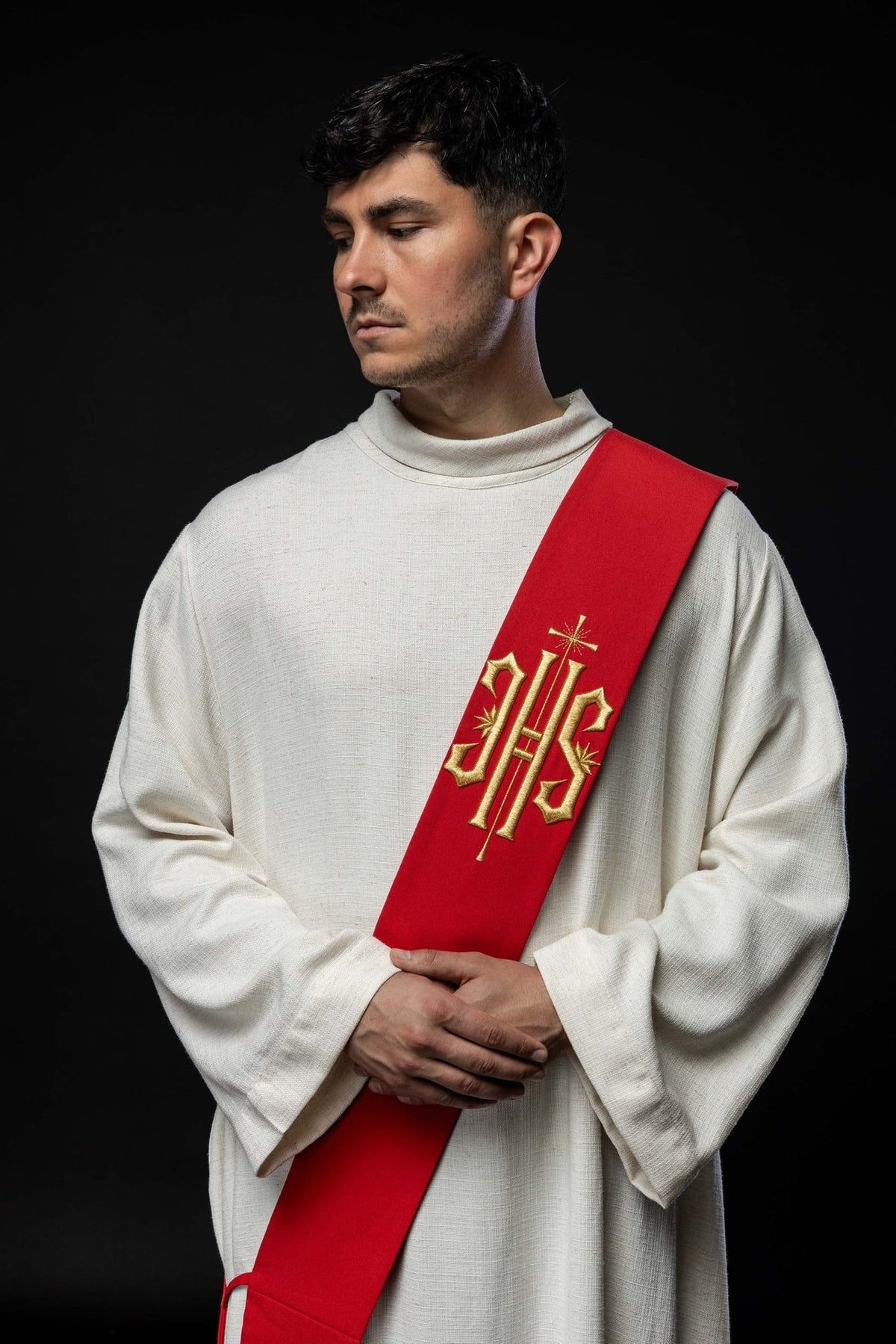 Red deacon stole worn in a front view with gold IHS embroidery