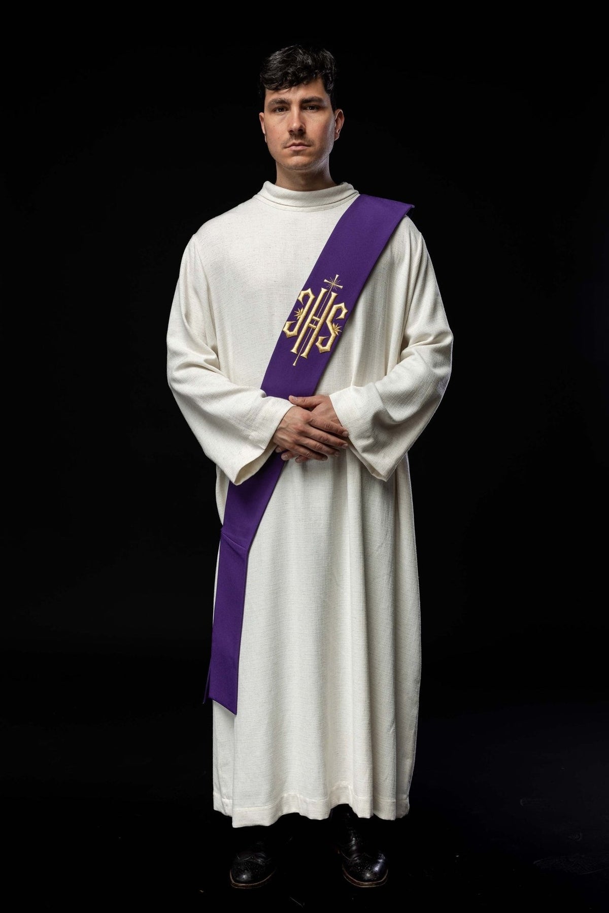 Purple embroidered deacon stole worn full length, showing front IHS and cross