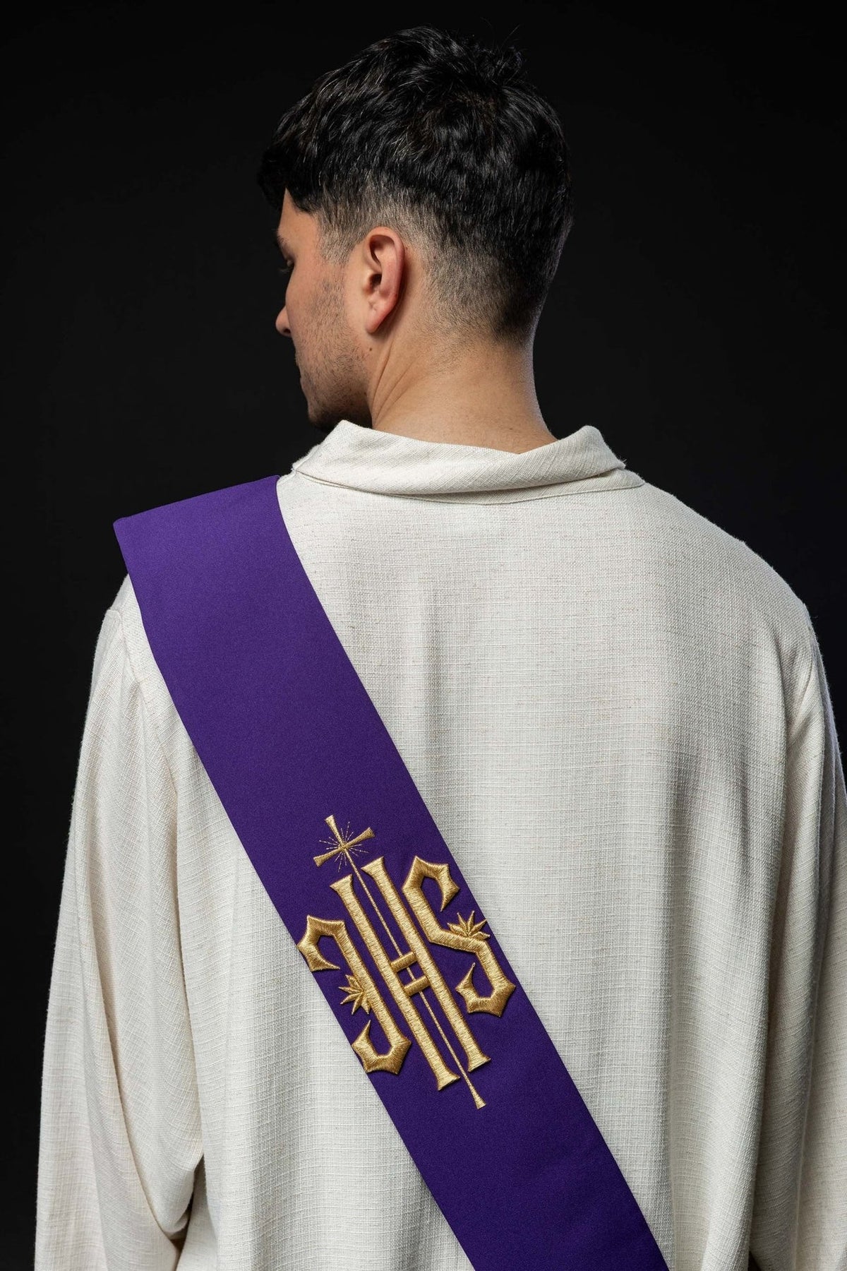 Purple embroidered stole worn from the back with gold IHS and cross