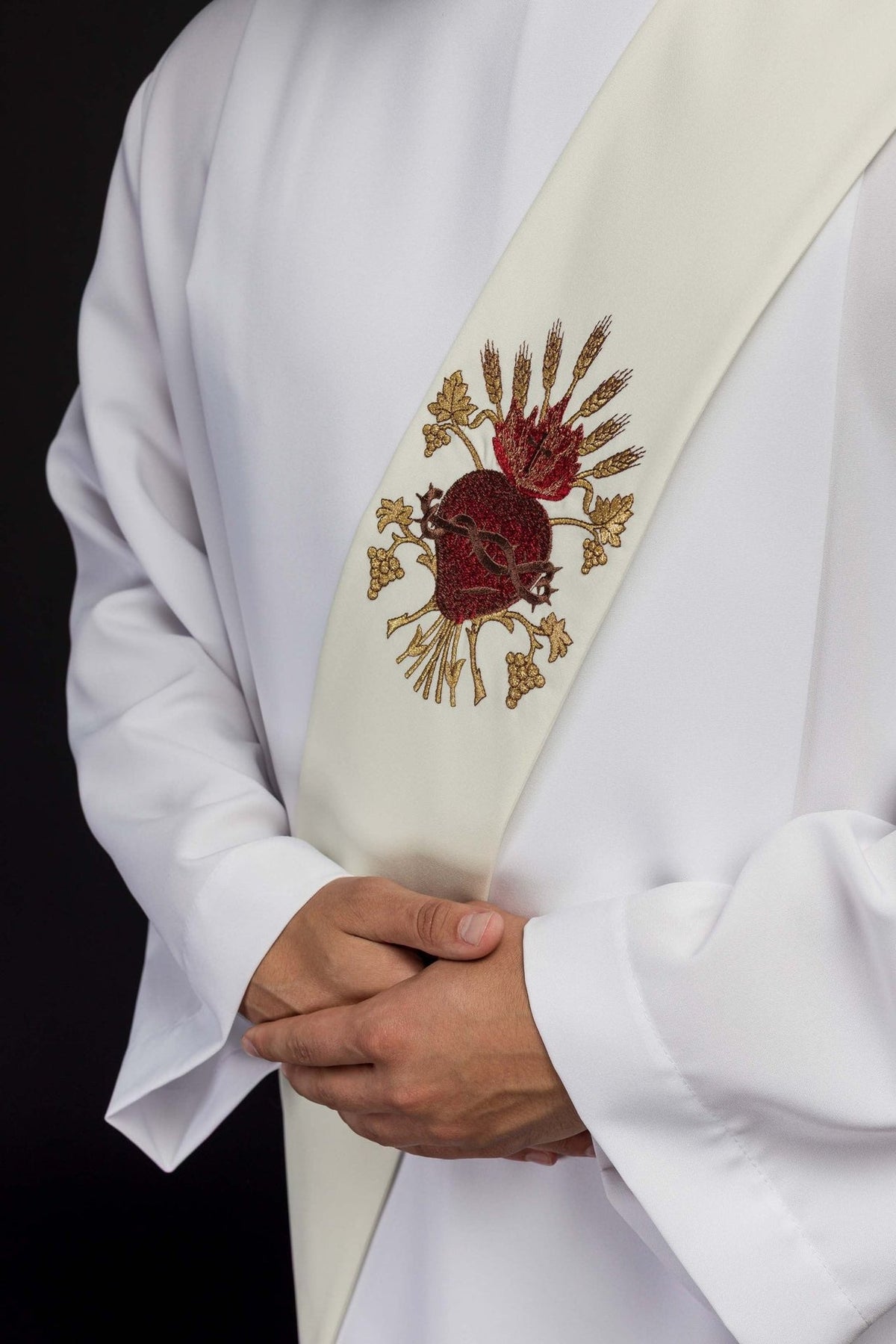 Deacon stole close-up showing the red Sacred Heart of Jesus and gold embroidery on ivory fabric