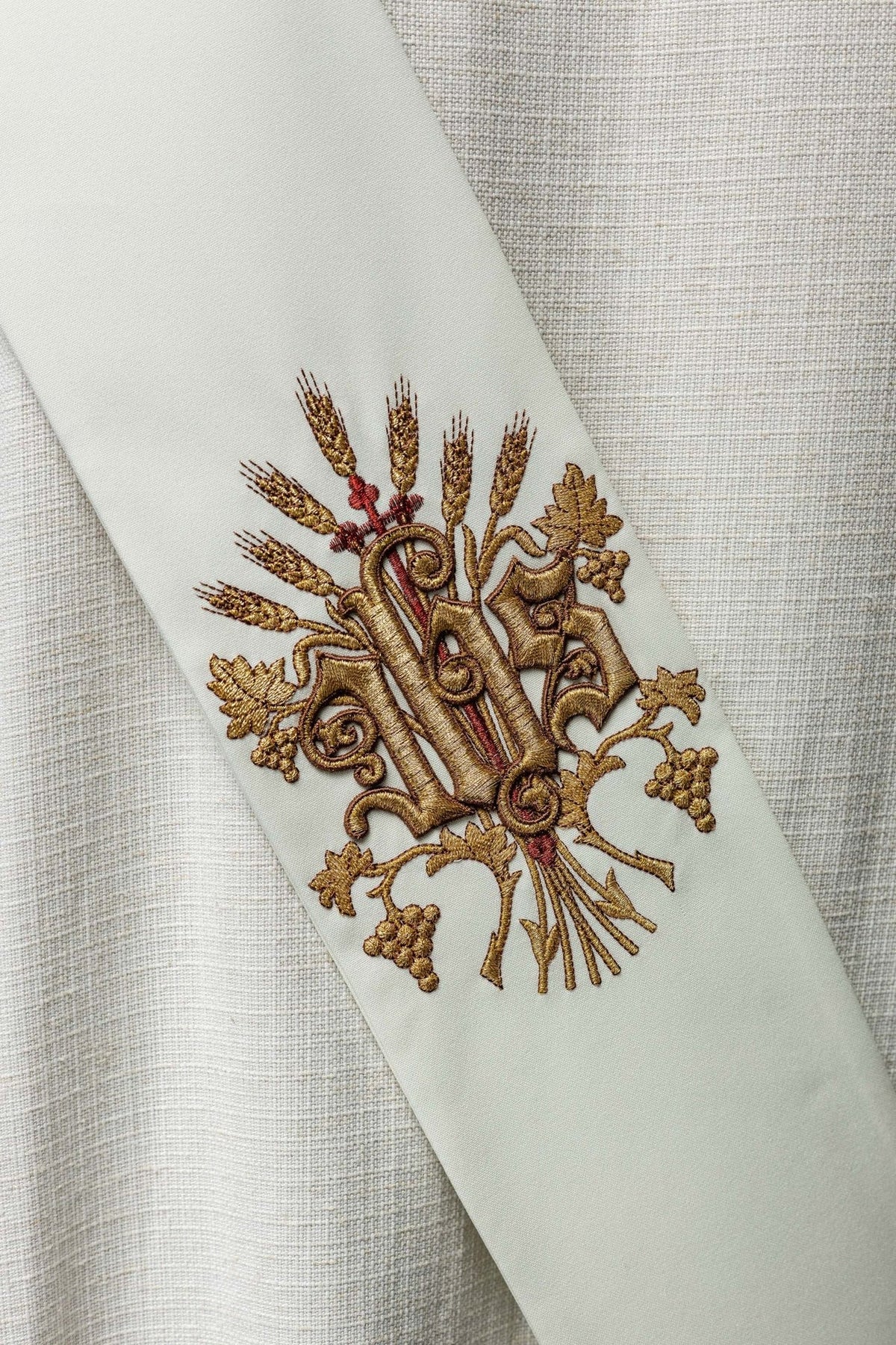 Close-up of embroidered grapes, wheat and cross on the white stole