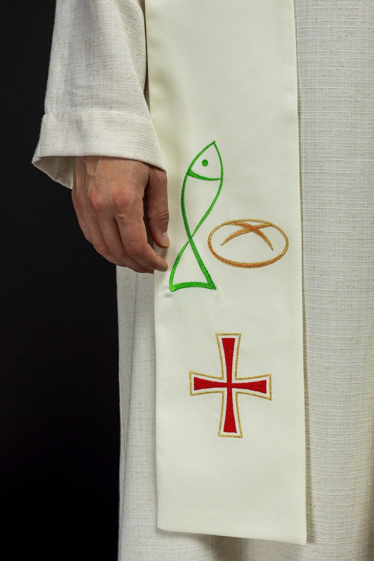 Ecru stole close-up showing green fish, bread and red cross embroidery