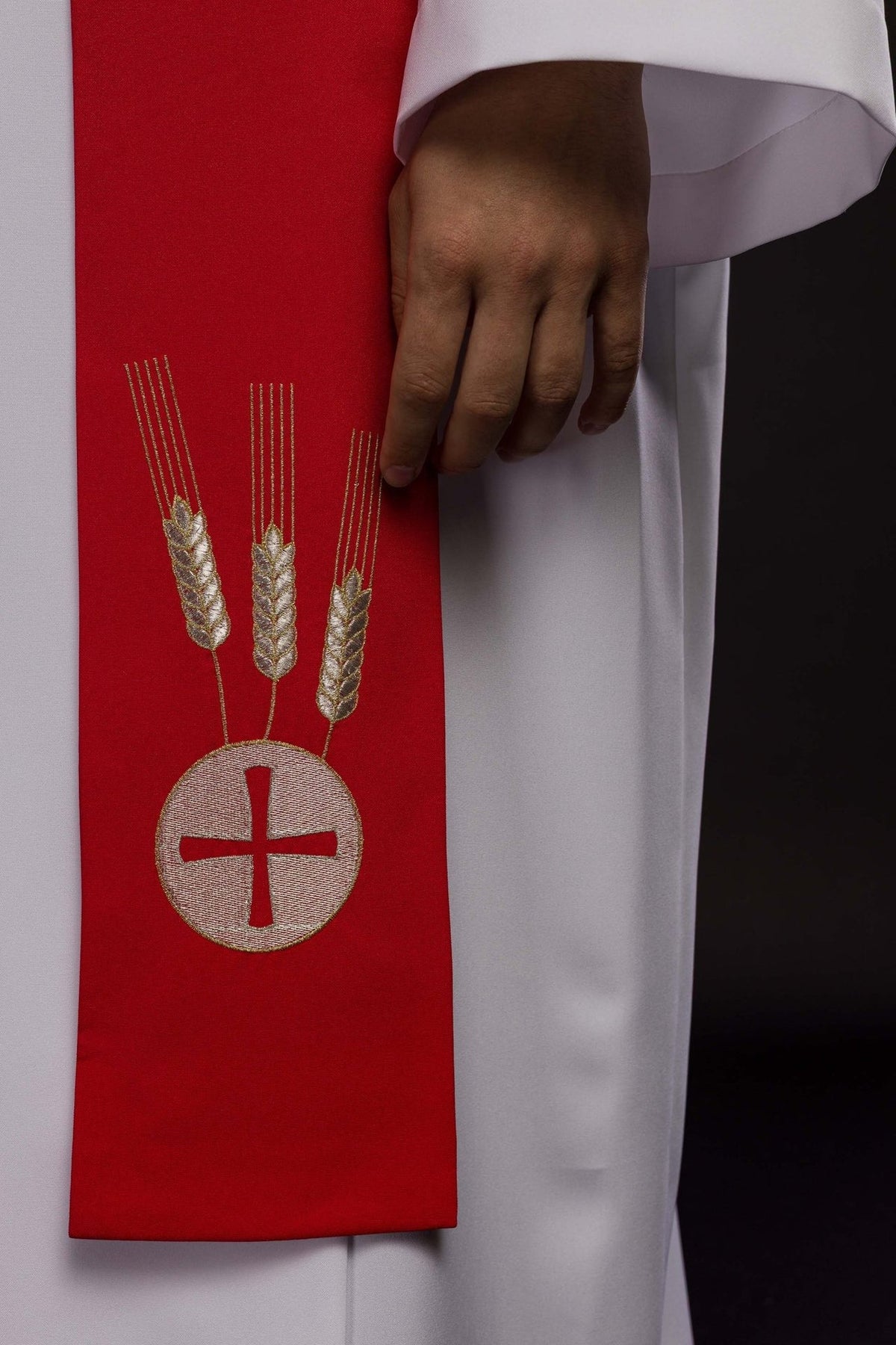 Red stole close-up showing embroidered wheat and cross