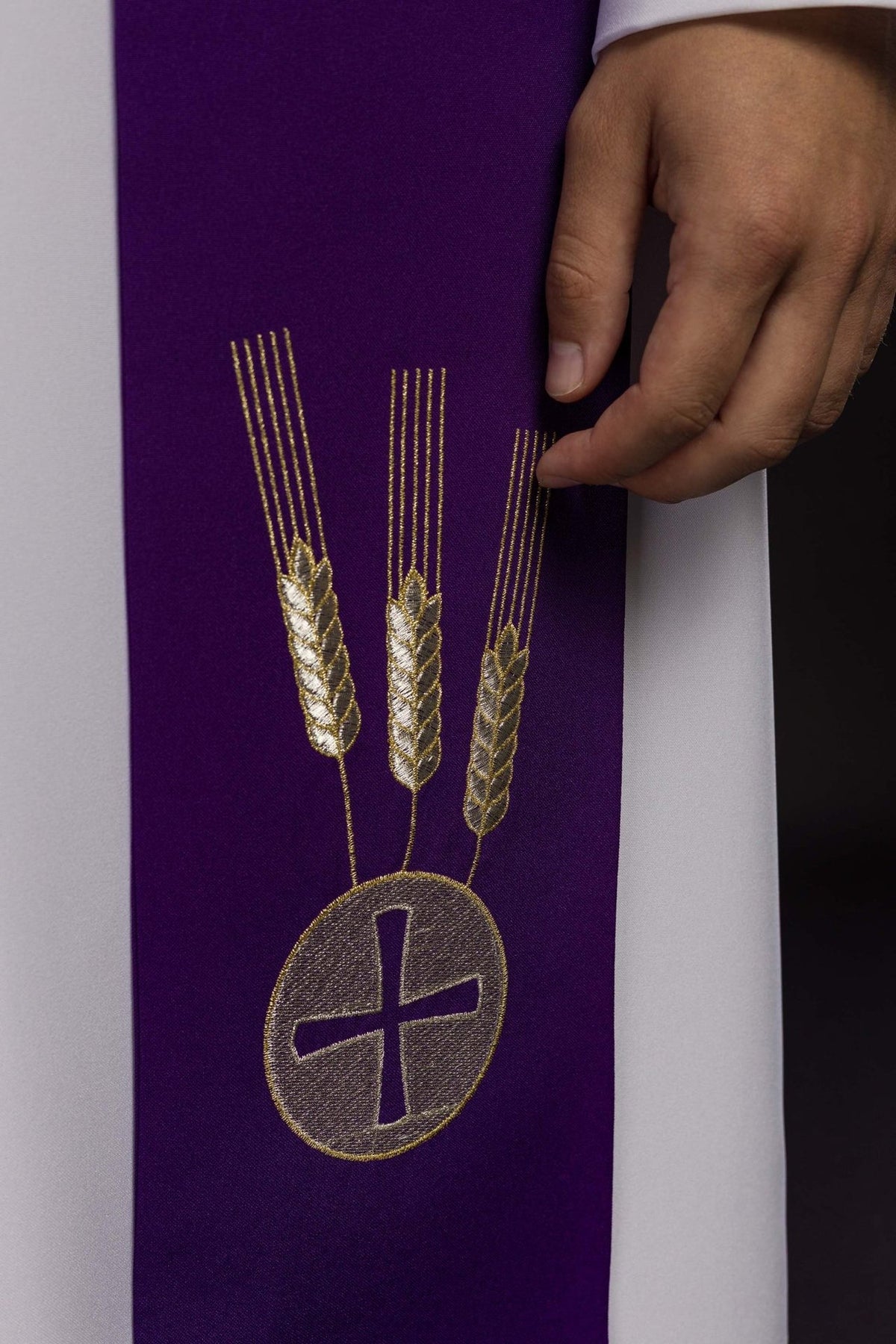 Purple stole close-up with embroidered wheat and cross medallion